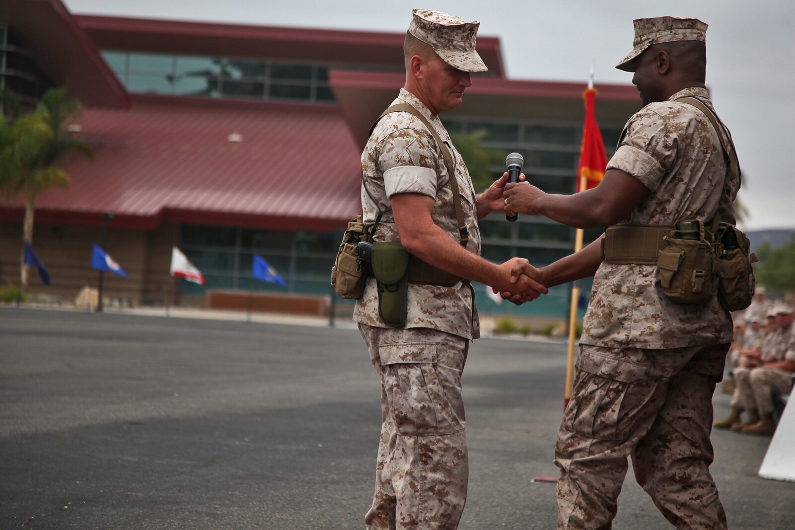 Colonel Tracy King, out-going commanding officer, Combat Logistics Regiment 15, shakes hands with Col. Seth Ocloo, incoming commanding officer, CLR-15, during the unit’s change of command ceremony aboard Camp Pendleton, Calif., May 22, 2014. Ocloo, who recently served as the assistant chief of staff for logistics at the 3rd Marine Aircraft Wing, received his new duty with enthusiasm.