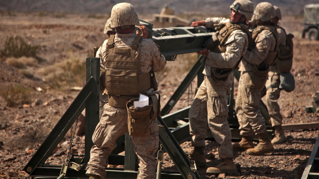 Marines with Bridge Company, 7th Engineer Support Battalion, 1st Marine Logistics Group, construct the roller beam base of a medium girder bridge during Exercise Desert Scimitar 2014 aboard Twentynine Palms, Calif., May 16, 2014. DS 14 is an annual exercise held by 1st Marine Division, in which 1st MLG serves as their tactical logistics support. The bridge they built provided transportation across a 66-foot gap, allowing Marines with 2nd Battalion, 7th Marine Regiment, 1st Mar. Div., the ability to engage the "enemy" over the space.
