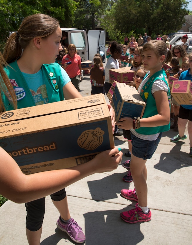 Girl Scouts pass boxes of cookies to each other to donate to the USO of North Carolina in Jacksonville during Operation Cookie Drop, May 22. The USO will use the cookies for homecomings, deployments and other events for service members and their families.