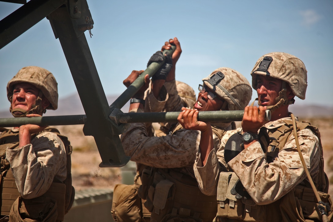 Corporal Howard Savage, (center) and Lance Cpl. Zachary Katanik, (right) combat engineers with Bridge Company, 7th Engineer Support Battalion, 1st Marine Logistics Group, lift a top panel, weighing close to 400 pounds, with the help of Cpl. Julien Vanbiesbrouck,(left) a motor transport operator with Bridge Co., during Exercise Desert Scimitar 2014 aboard Twentynine Palms, Calif., May 16, 2014. DS 14 is an annual exercise held by 1st Marine Division, in which 1st MLG serves as their tactical logistics support. The bridge they built provided transportation across a 66-foot gap, allowing Marines with 2nd Battalion, 7th Marine Regiment, 1st Mar. Div., the ability to engage the “enemy” over the space.