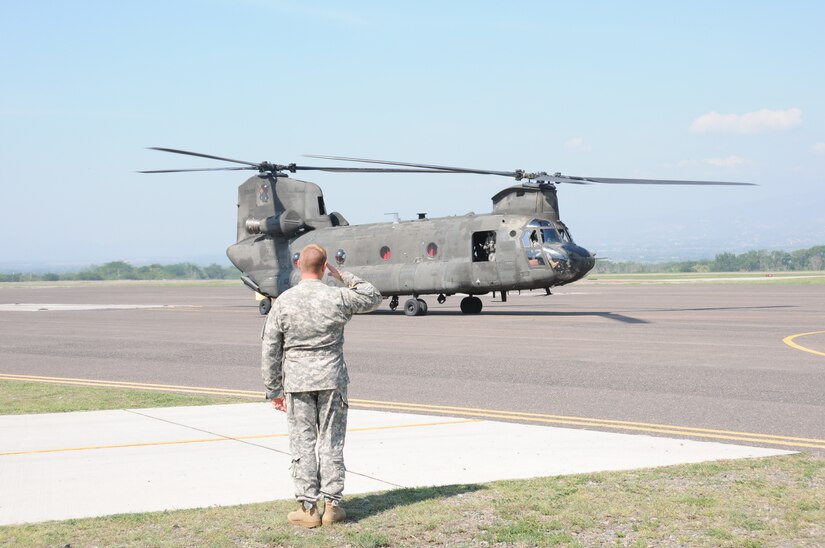 U. S. Army Lt. Col. Ernest Irvin, 1-228th Aviation Regiment commander, salutes as a CH-47D Chinook prepares to take off from Soto Cano Air Base, Honduras for the last time, May 28, 2014.  Two Chinooks are slated to be replaced with the newer CH-47F model.  One of the helicopterss, affectionately known as "638", is the oldest active Chinook in the U. S. Army's inventory having flown in the Vietnam War.  (Photo by U. S. Air National Guard Capt. Steven Stubbs)