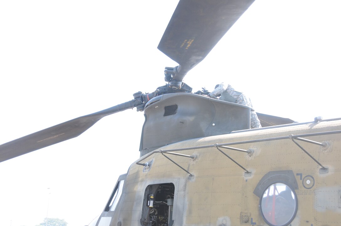 A CH-47D Chinook crew chief performs pre-flight checks before departing Soto Cano Air Base, Honduras for the last time, May 28, 2014.  Two Chinooks attached to the 1-228th Aviation Regiment are slated to be replaced with the newer CH-47F model.  One of the helicopterss, affectionately known as "638", is the oldest active Chinook in the U. S. Army's inventory having flown in the Vietnam War.  (Photo by U. S. Air National Guard Capt. Steven Stubbs)