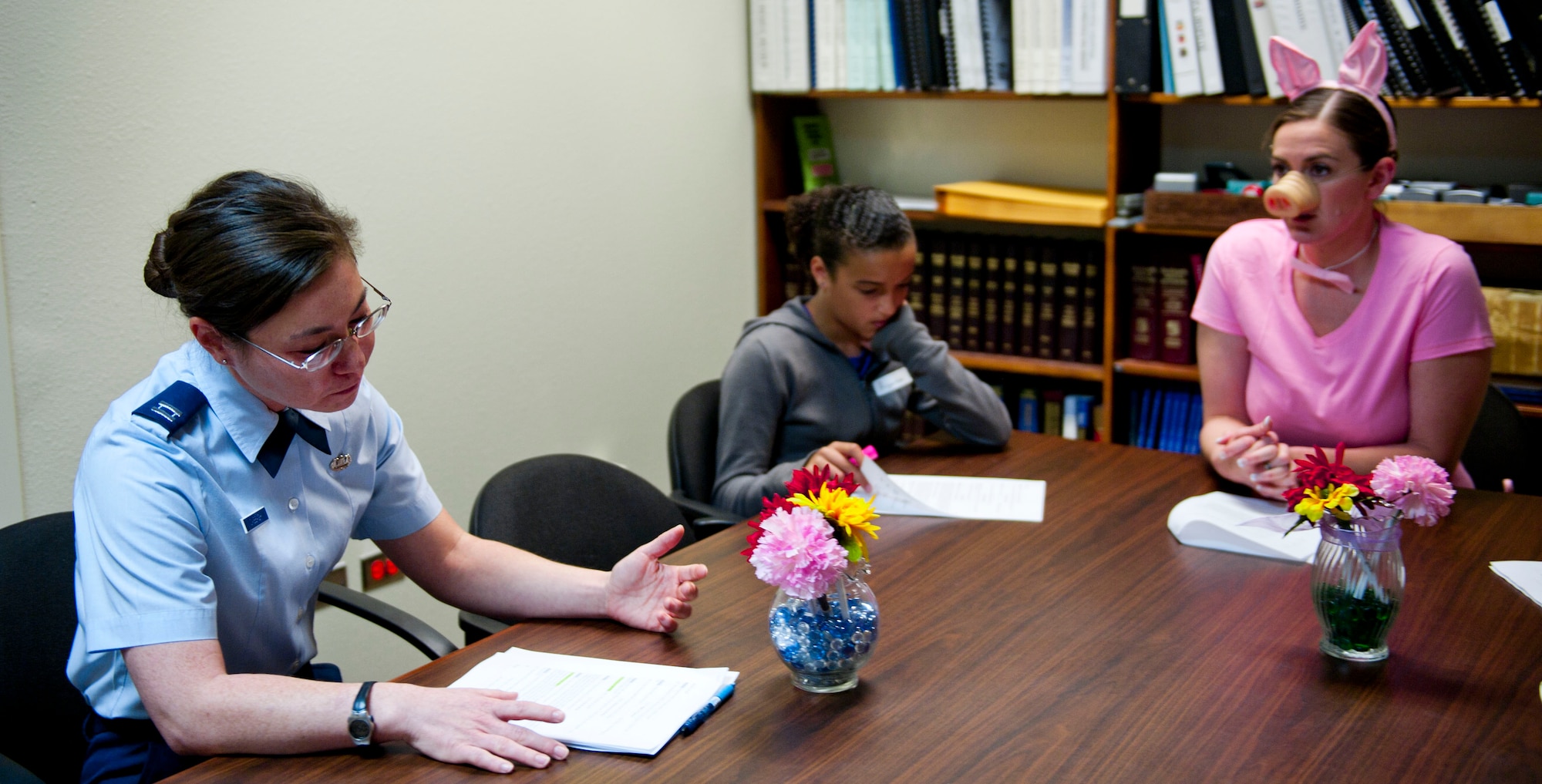 Capt. Daad Dabbagh, 366th Fighter Wing Judge Advocate assistance staff judge advocate, prepares an argument with her team on behalf of Mr. Curly Pig May 28, 2014, at Mountain Home Air Force Base, Idaho.  The children acted out their assigned roles during the mock trial as part of Law Day. (U.S. Air Force photo by Airman 1st Class Malissa Lott/RELEASED)