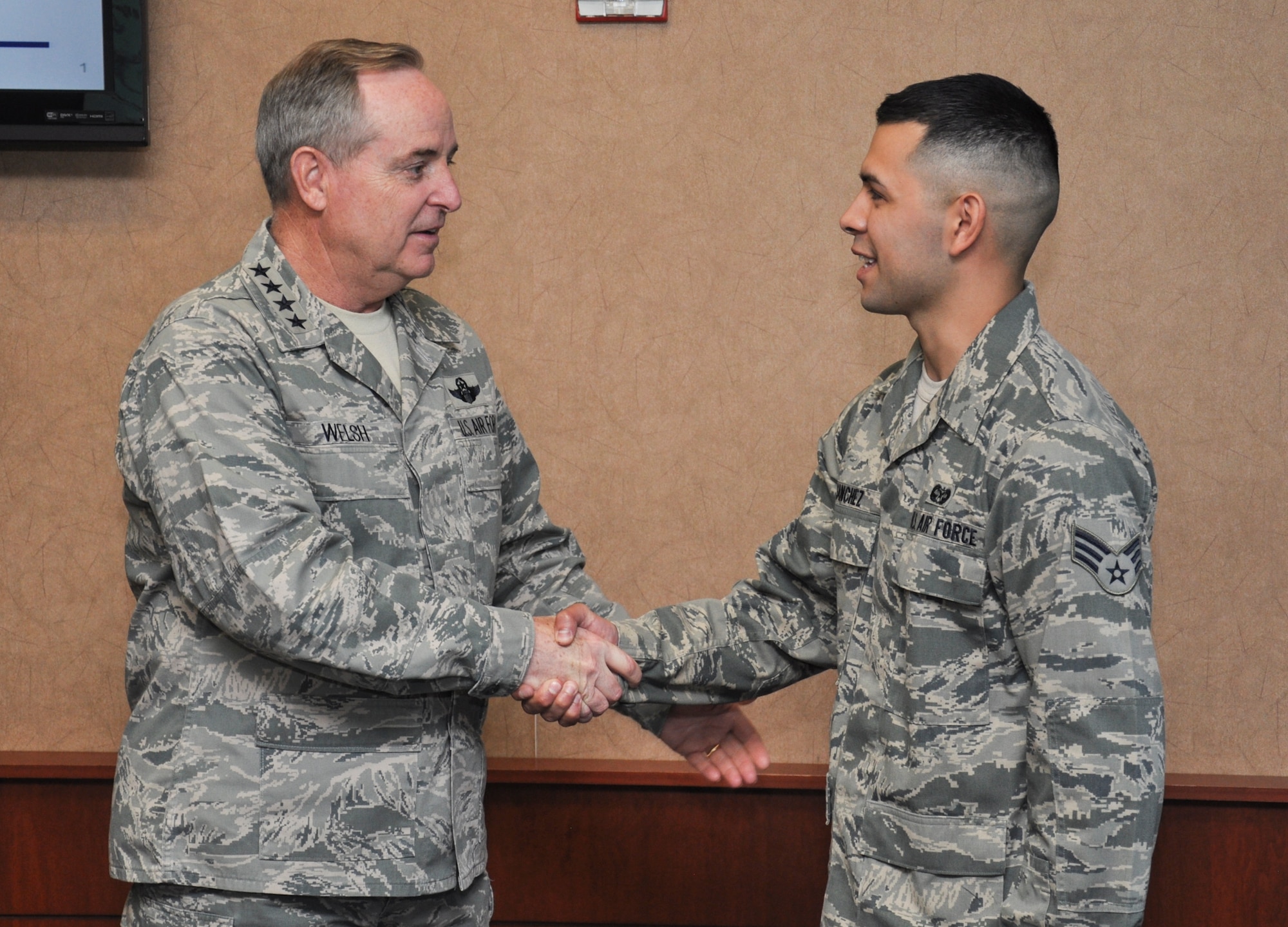 Air Force Chief of Staff Gen. Mark A. Welsh III coins Senior Airman Jose Sanchez, 460th Space Wing legal office, during a visit May 27, 2014, to Buckley Air Force Base, Colo. Welsh’s trip to Buckley included mission briefings, Airmen recognition and a chance for the base to meet the Air Force’s top officer. (U.S. Air Force photo by 2nd Lt. Trevor Zakrzewski/Released)