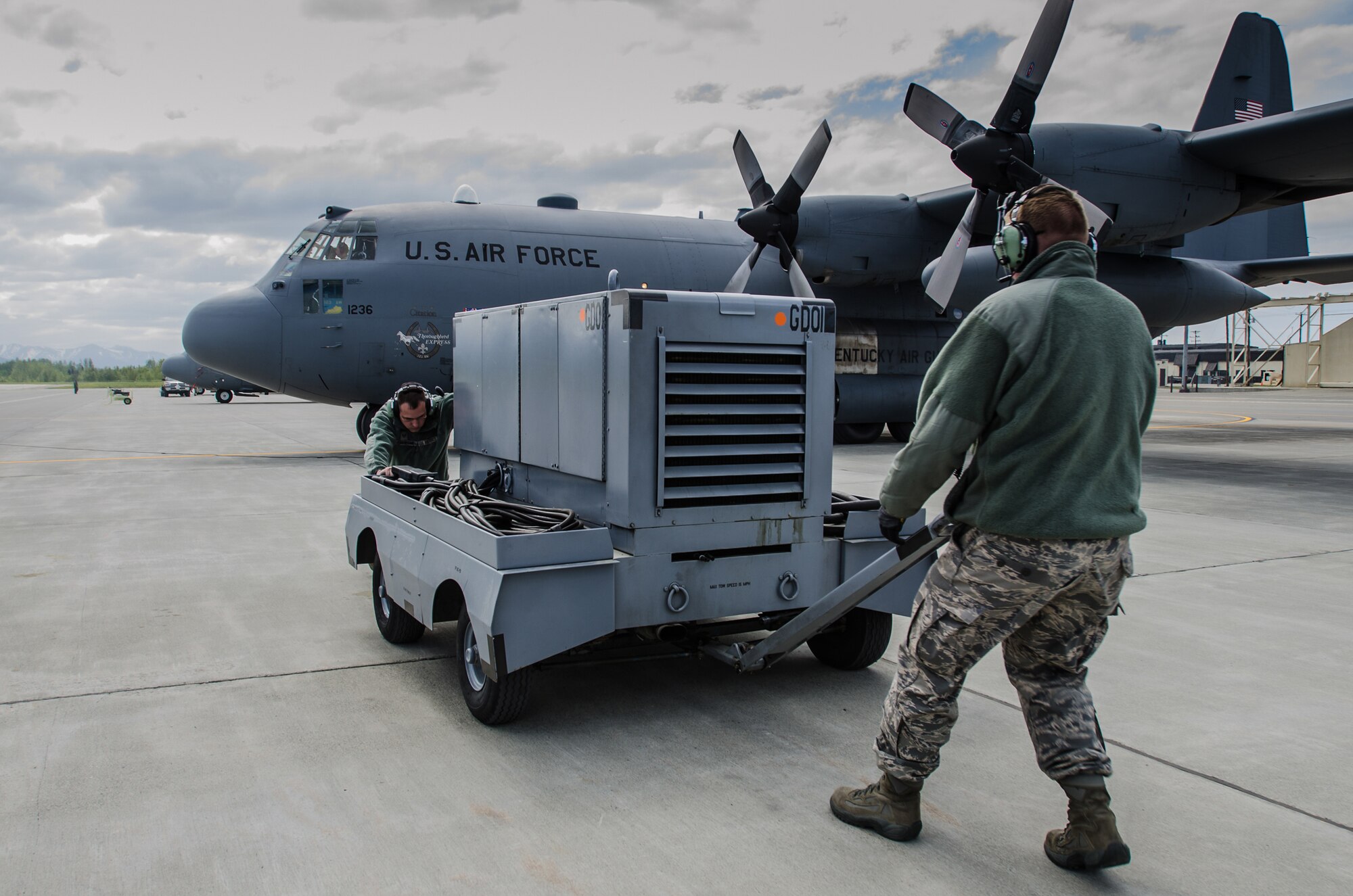 Staff Sgt. Dustin Pennington, an electric environmental craftsman from the Kentucky Air National Guard’s 123rd Maintenance Squadron, and Tech. Sgt. Christopher Julian, crew chief for Kentucky’s 123rd Aircraft Maintenance Squadron, move a power generator prior to the launch of a Kentucky Air Guard C-130 Hercules at Joint Base Elmendorf-Richardson, Alaska, on May 19, 2014. More than 100 Kentucky Airmen participated in exercise Red Flag-Alaska from May 7 to 23. (U.S. Air National Guard photo by Master Sgt. Phil Speck)