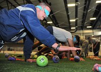 Members of the 319th Air Base Wing crawl through a pretend mine field while blindfolded on May 22, 2014, at the fitness center on Grand Forks Air Force Base, N.D. The mine field activity is a sensory team building exercise focusing on communcation skills. (U.S. Air Force photo/Senior Airman Xavier Navarro) 