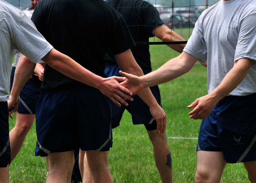 Airmen from Team Dover show good sportsmanship after they compete in the volleyball competition during Wingman Day May 22, 2014, at the Eagles Nest Park on Dover Air Force Base, Del. Games were played to 15 and rally point scoring was used to expedite the games. (U.S. Air Force photo/Staff Sgt. Elizabeth Morris)