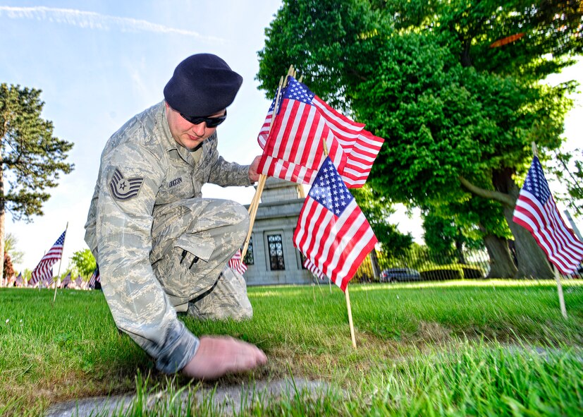 914th Airlift Wing Security Forces Tech. Sgt. Derek Duggan places an American flag on a veteran’s grave during a Memorial Day ceremony held at Forest Lawn Cemetery on May 25, 2014, Buffalo NY. During the morning ceremony volunteers placed thousands of flags next to the graves of the men and woman who served in the United States military. (U.S. Air Force photo by Tech. Sgt. Joseph McKee)