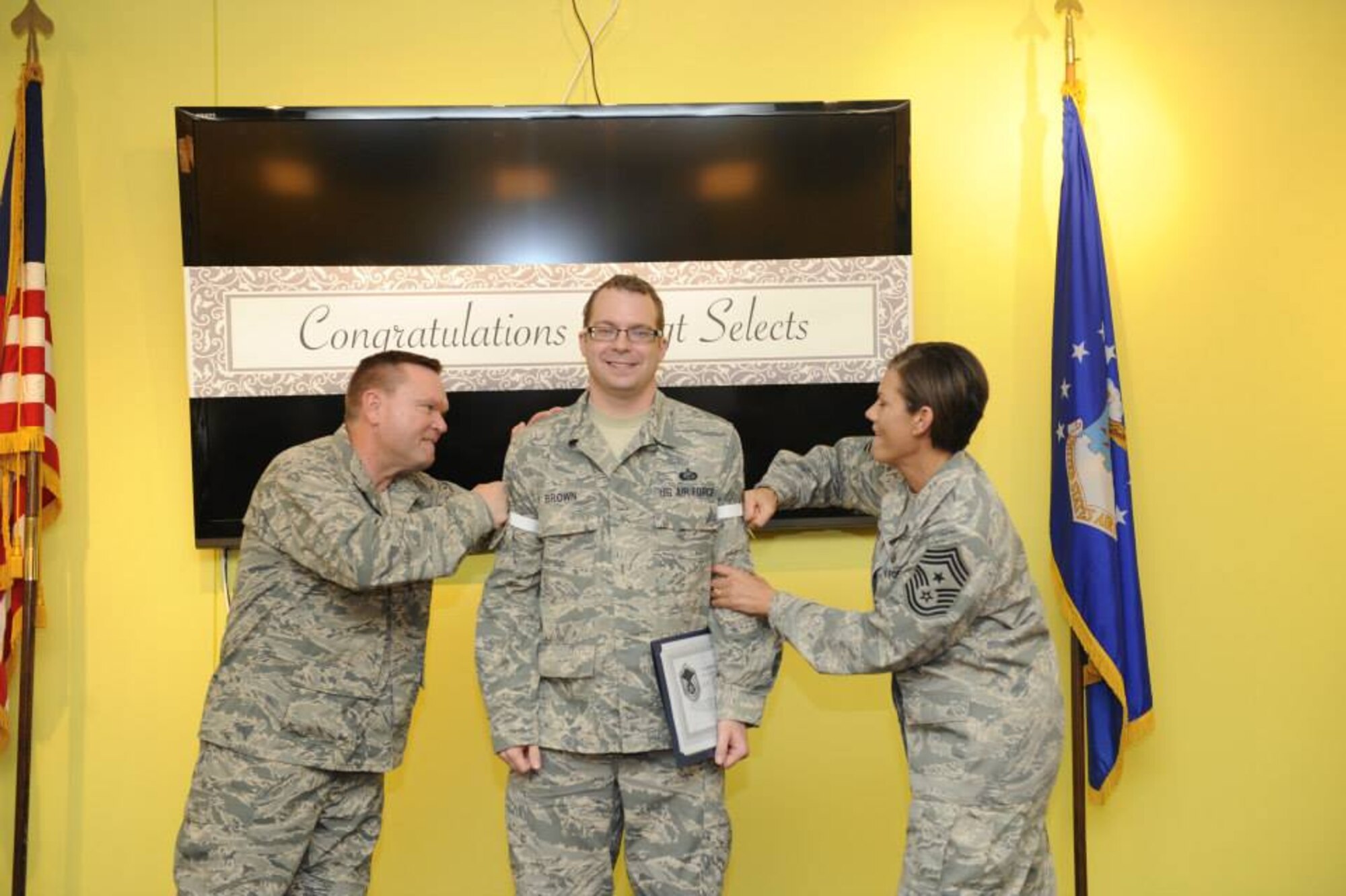 Brig. Gen. Samuel "Bo" Mahaney, Air Reserve Personnel Center commander, and Chief Master Sgt. Ruthe Flores, ARPC command chief, punch master sergeant stripes on Tech. Sgt. Scott Brown, promotion board operations NCO in charge, during Team Buckley's master sergeant release party May 22. (U.S. Air Force photo by Airman 1st Class Samantha Saulsbury)