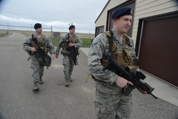 From right to left Senior Airman Scott Leithheiser, Senior Airman Trent Obrien, and Tech. Sgt. Cody Chick, all of the 219th Security Forces Squadron, return from the gate of a Minot Air Force Base, N.D., missile alert facility, after granting access to authorized personnel entering the facility May 20, 2014. The North Dakota Air National Guard enlisted members are doing their annual training while performing the real-World mission of missile field security, which allows their active duty counterparts to catch up on other training and mission requirements.  (U.S. Air National Guard photo by SMSgt. David H. Lipp/Released)