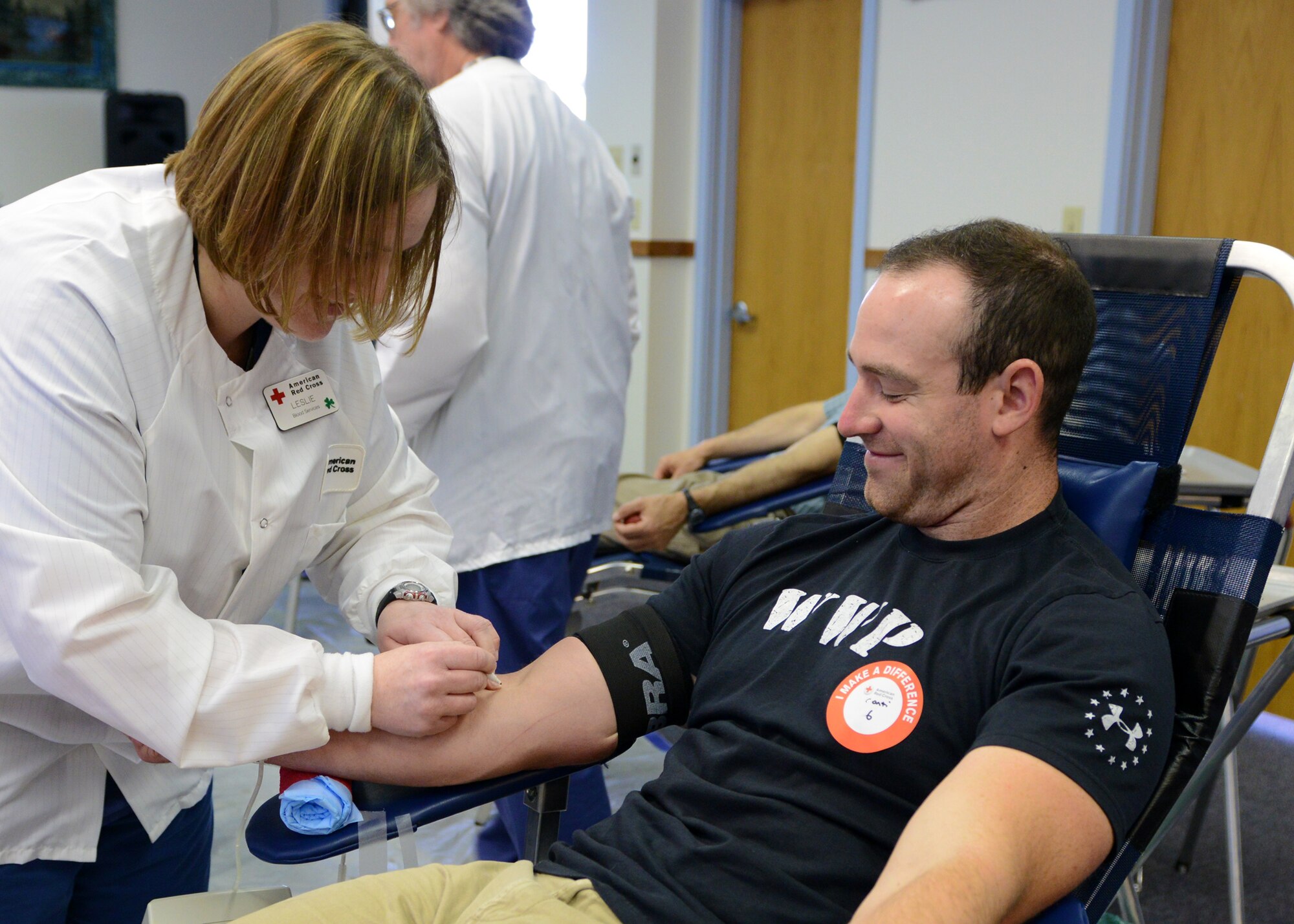 Leslie Regan, Great Falls American Red Cross phlebotomist (left), prepares to draw blood from Airman Anthony Conti, 341st Missile Security Forces Squadron alert response team leader during a First Strike Blood Drive Challenge at the Malmstrom Air Force Base Chapel on May 28. The competition is amongst the five Malmstrom groups, as well as Wing Staff Agencies and the 819th RED HORSE Squadron, to see which group can donate the most blood and take home the coveted trophy. The next blood drive is scheduled for June 23 at the base chapel. (U.S. Air Force photo/Senior Airman Katrina Heikkinen)
