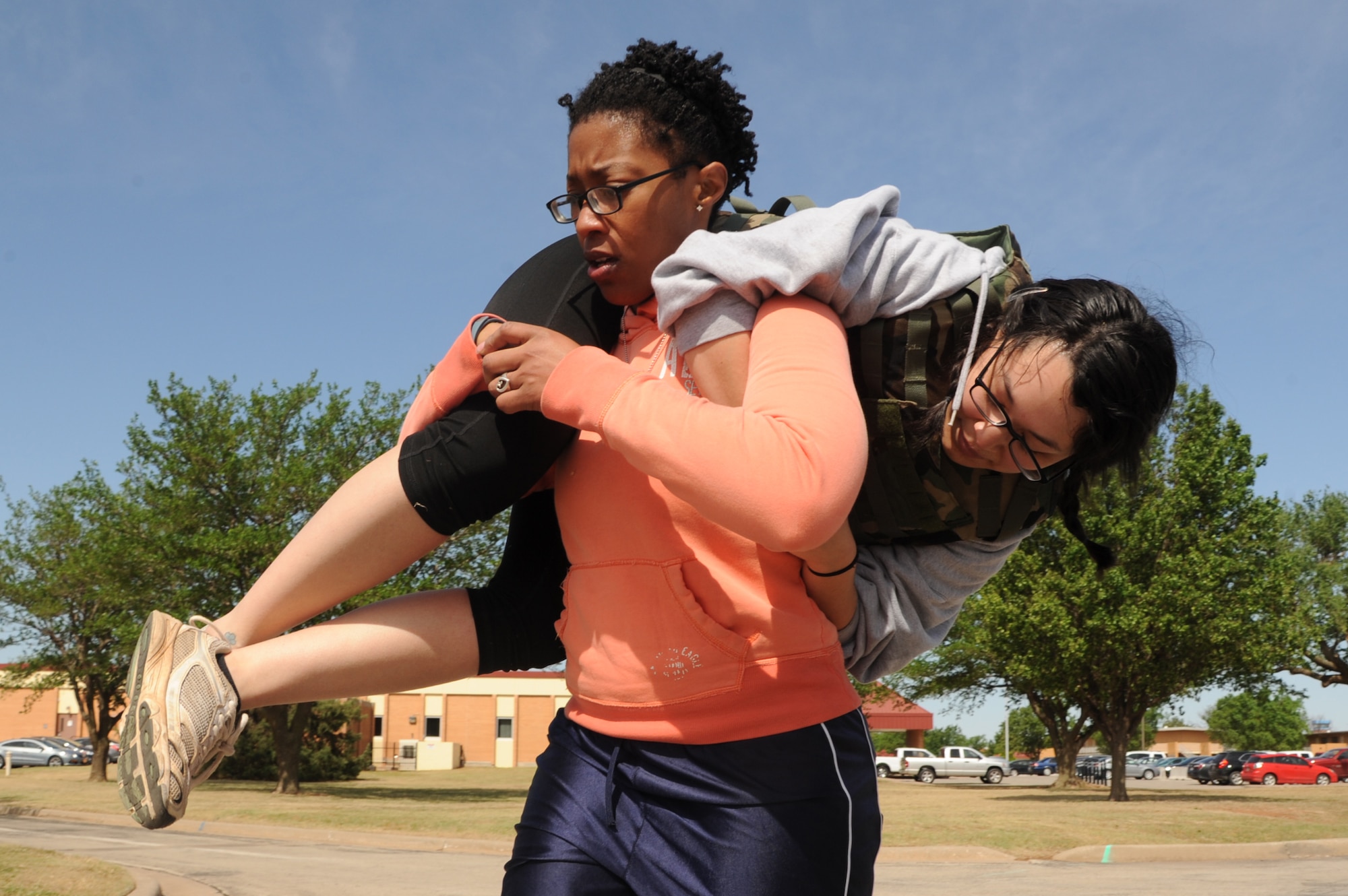 VANCE AIR FORCE BASE, Okla. -- Staff Sgt. Kira Cox, with the 71st Medical Group, fireman carries Senior Airman Alysia Uribe, also with the 71st MDG, during the Defender’s Challenge May 13 on base. For the past three years the 71st SFS has put together an obstacle course they dubbed the “Defender’s Challenge.” (U.S. Air Force photo/Senior Airman Frank Casciotta)