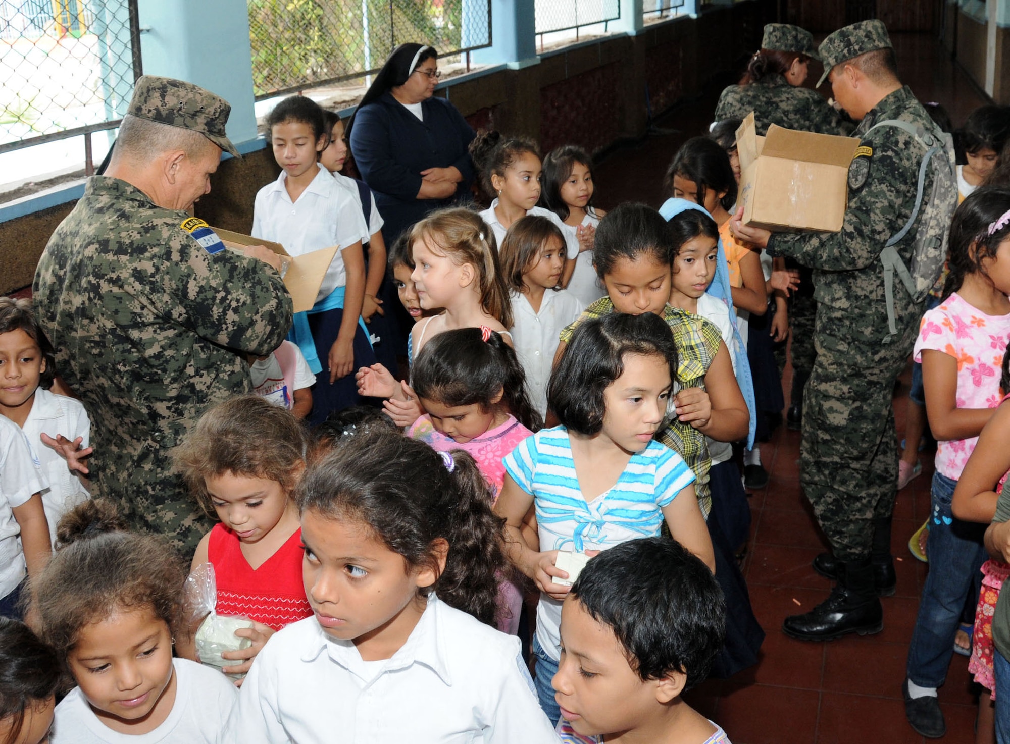 Personnel from the Honduran 21st Military Police Battalion hand out soap kits to the children of the Hogar del Nino school.  Joint Task Force-Bravo, non-government organizations Clean the World, Bridge Ministries and Kick for Nick Foundation, the Honduran 21st Military Police Battalion and the Honduran National Police formed a partnership to distribute soap kits, backpacks with school supplies, tooth brushes and tooth paste, soccer balls and uniforms to students at eight Tegucigalpa, Honduras schools in a two-day event, May 20-21, 2014.  The group handed out over 4,200 soap kits, 600 backpacks, 150 tooth brushes and tooth paste, and 50 soccer balls.  (Photo by U. S. Air National Guard Capt. Steven Stubbs)