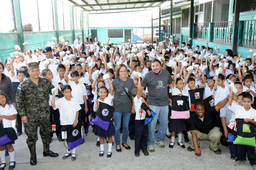 Children at the Enma Romero de Callejas school show off their soap kits with volunteers from Bridge Ministries and the Honduras 21st Military Police Battalion.  Joint Task Force-Bravo, non-government organizations Clean the World, Bridge Ministries and Kick for Nick Foundation, the Honduran 21st Military Police Battalion and the Honduran National Police formed a partnership to distribute soap kits, backpacks with school supplies, tooth brushes and tooth paste, soccer balls and uniforms to students at eight Tegucigalpa, Honduras schools in a two-day event, May 20-21, 2014.  The group handed out over 4,200 soap kits, 600 backpacks, 150 tooth brushes and tooth paste, and 50 soccer balls.  (Photo by U. S. Air National Guard Capt. Steven Stubbs)