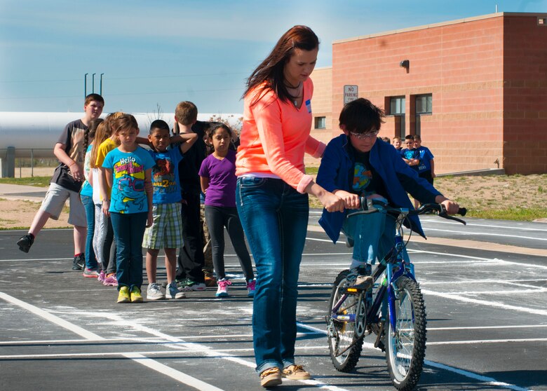 Airman 1st Class Kayla Elliott, 50th Security Forces Squadron, helps an Ellicott Elementary School student ride a bike during the school’s bike rodeo on May 19, 2014, in Ellicott, Colo. Elliott and other Airmen from Schriever Air Force Base volunteered to spend the teach fourth-graders how to ride a bike. (U.S. Air Force photo/Senior Airman Naomi Griego)  