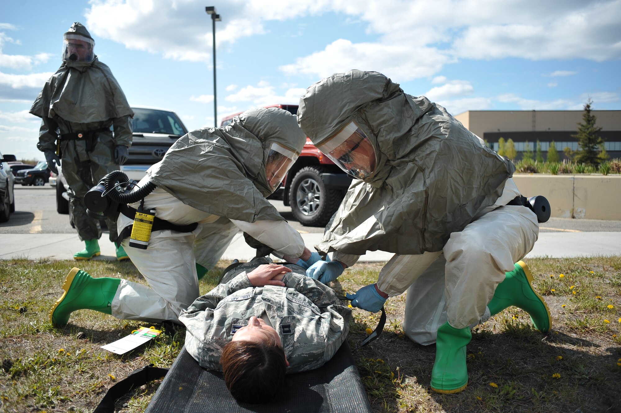 U.S. Air Force Maj. Tyetus Hohnstein and Capt. Jeremy Matis, 354th Medical Operations Squadron dentists, prepare an injured patient for transport during a chemical, biological, radiological and nuclear medical training exercise May 21, 2014, Eielson Air Force Base, Alaska. The 354th Medical Group tested their response capabilities in response to a simulated chemical spill. (U.S. Air Force photo by Staff Sgt. Jim Araos/Released)