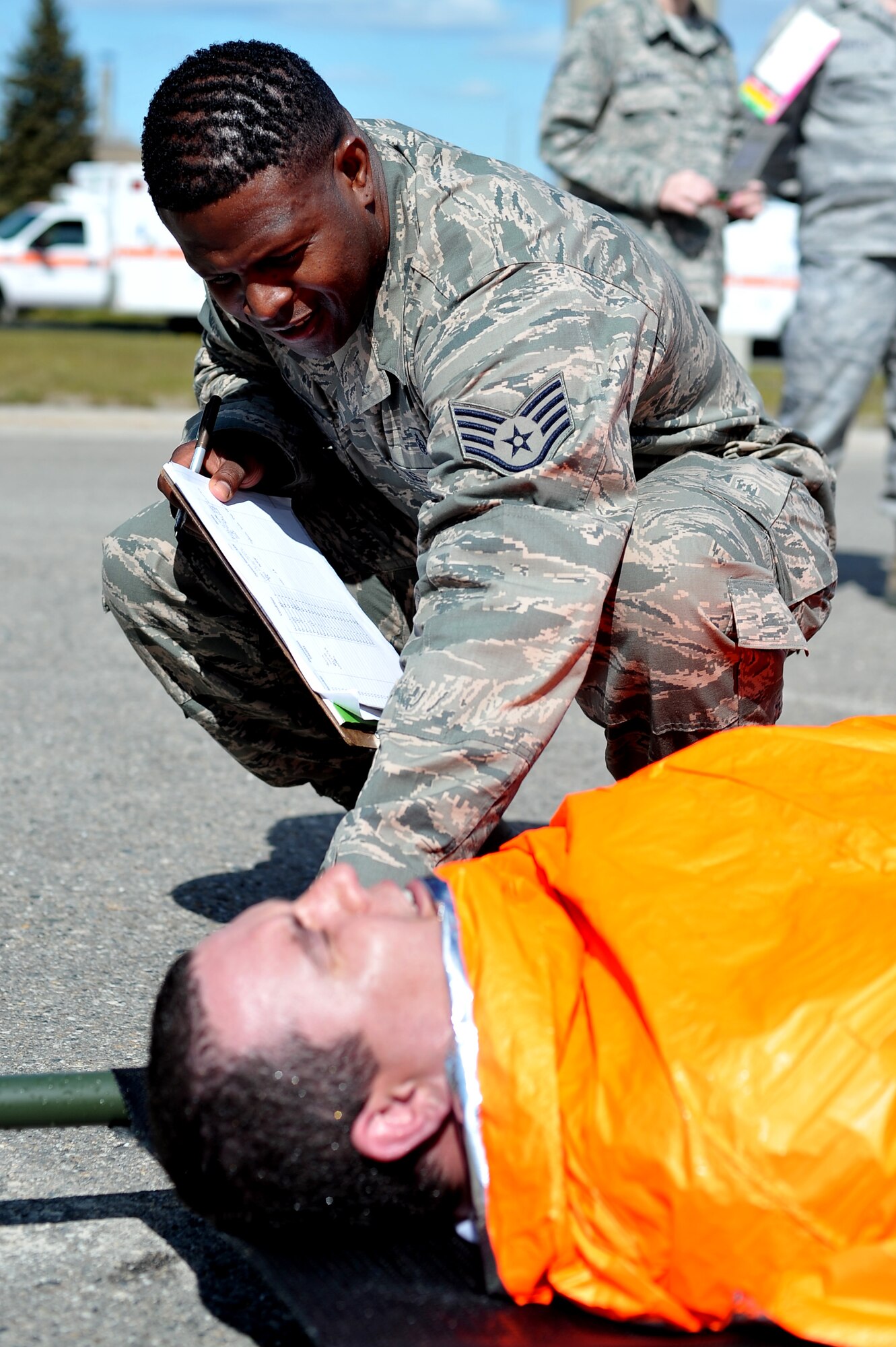 U.S. Air Force Staff Sgt. Augustus Moore, 354th Medical Support Squadron NCO in charge of patient administration and disposition team, assesses simulated chemical injuries on Staff Sgt. Adam Whiffen, 354th Medical Operations Squadron allergy immunizations technician, during a chemical, biological, radiological and nuclear medical training exercise May 21, 2014, Eielson Air Force Base, Alaska. After the decontamination process, patients are reexamined for additional medical treatment. (U.S. Air Force photo by Staff Sgt. Jim Araos/Released)