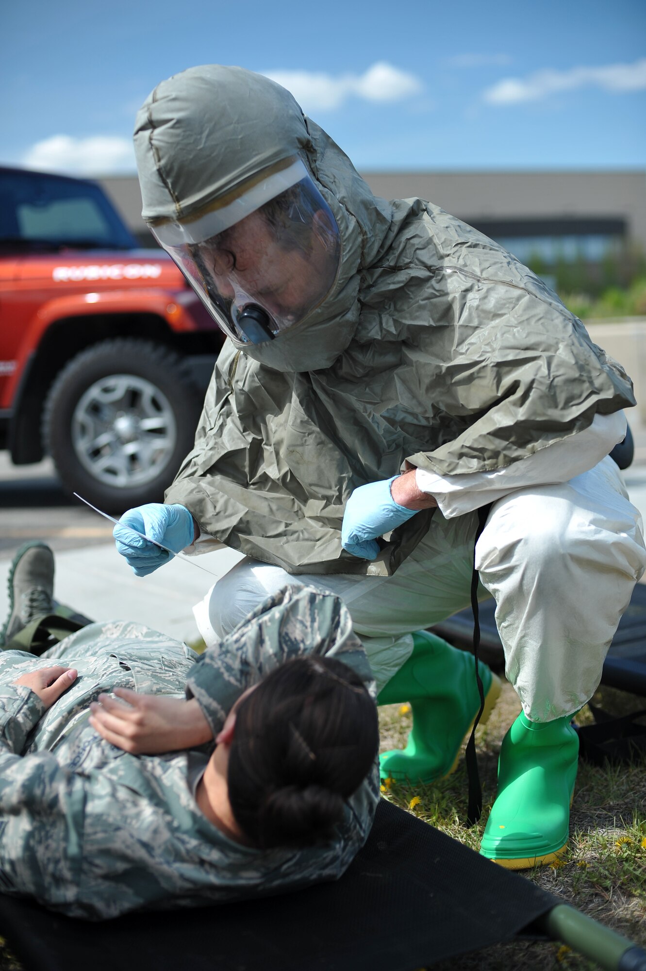 U.S. Air Force Maj. Tyetus Hohnstein, 354th Medical Operations Squadron dentist, assesses simulated chemical injuries during a chemical, biological, radiological and nuclear medical training exercise May 21, 2014, Eielson Air Force Base, Alaska. As a member of the triage team, Hohnstein examines and separates immediate care patients from a group of casualties. (U.S. Air Force photo by Staff Sgt. Jim Araos/Released)