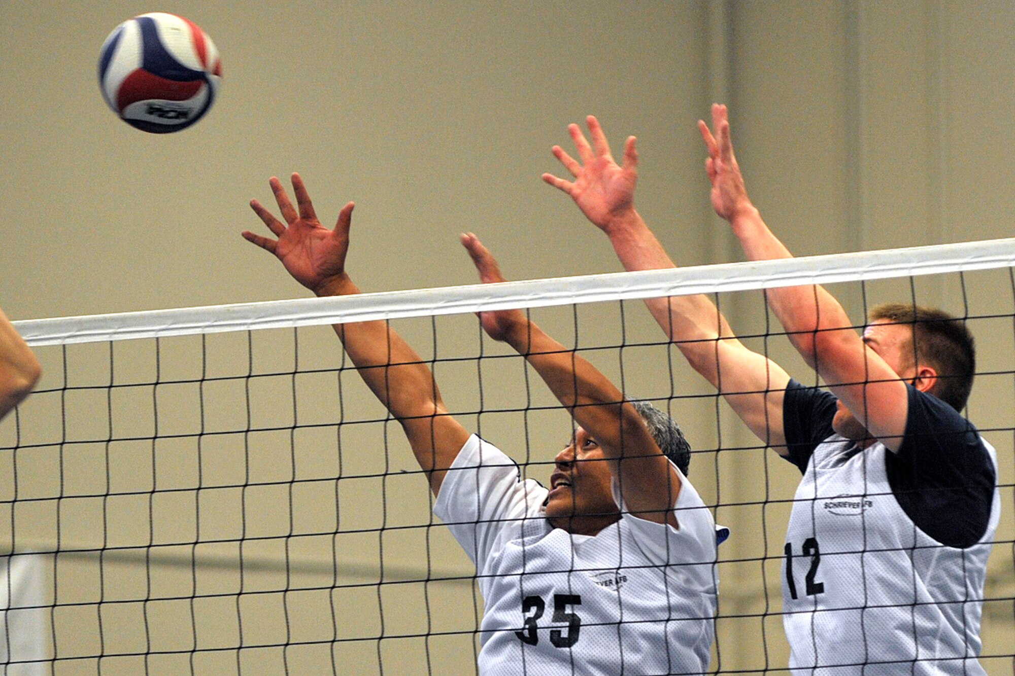 Players with the U.S. Air Force Academy attempt to block a shot at the net during the 2014 Rocky Mountain Regional Volleyball Tournament May 17, 2014, at Schriever Air Force Base, Colo.  The Schriever Fitness Center hosted the round robin tournament where volleyball teams from Fort Carson, Schriever, Peterson and Buckley Air Force Bases and U.S. Air Force Academy competed. (U.S. Air Force photo/Dennis Rogers)