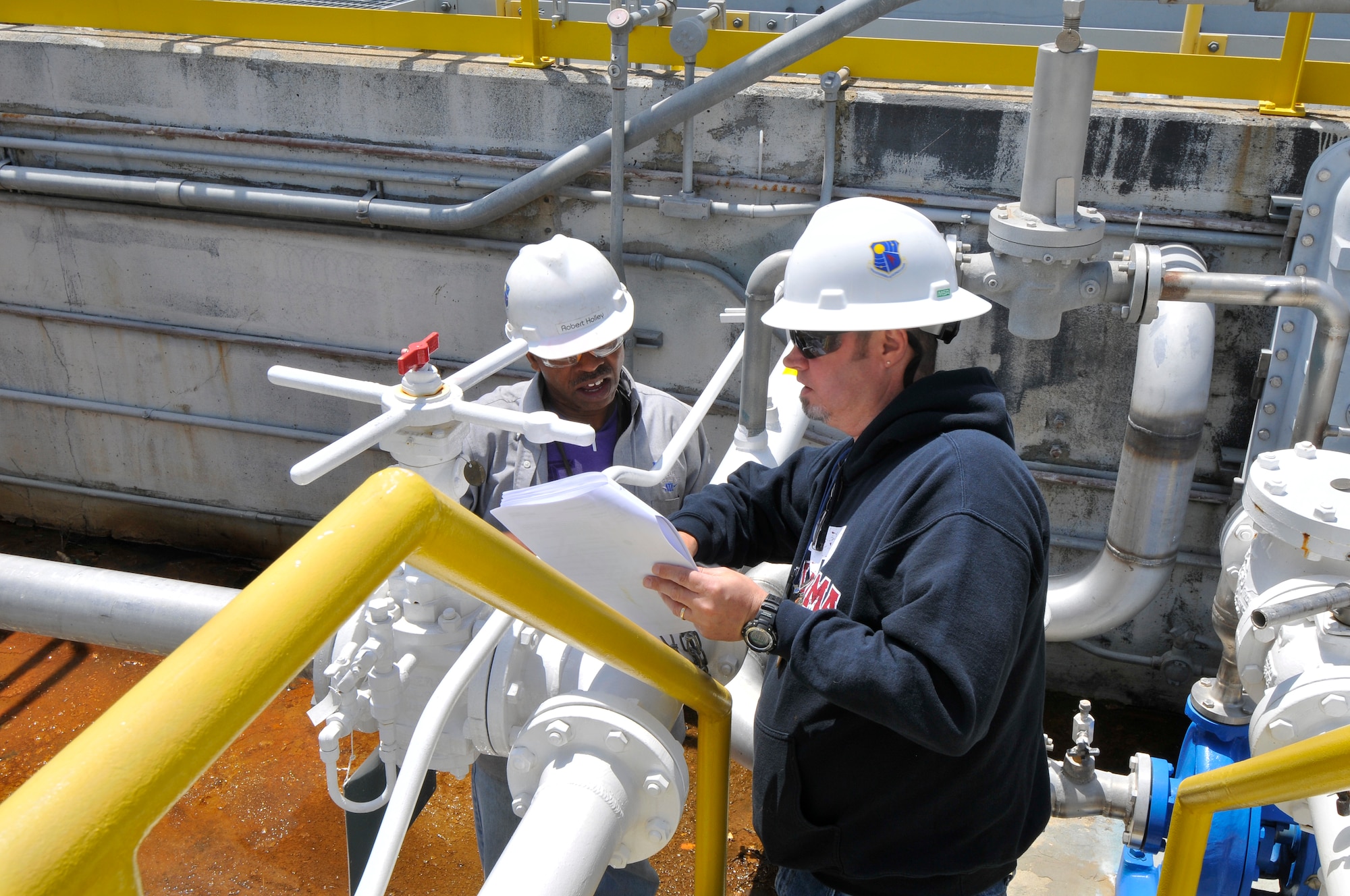 Robert Holley (left), from the Arnold Engineering Development Complex (AEDC) Fuel Farm, and Carl McGee, with the AEDC Aeropropulsion Systems Test Facility, discuss a work instruction and a safe plan of action prior to bringing up fuel pressure for a fuel system leak check utilizing Jet-A fuel. (Photo by Jacqueline Cowan)