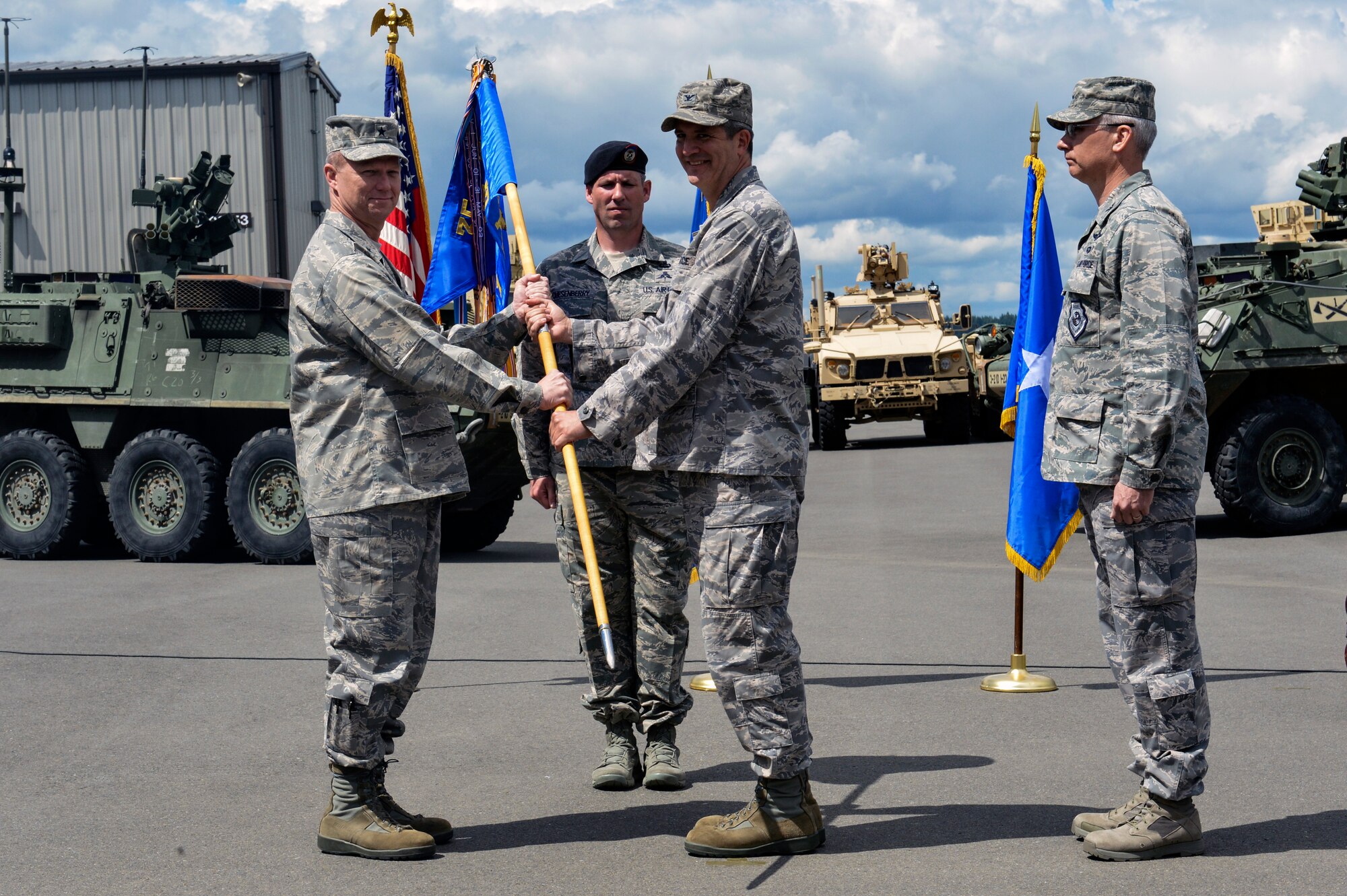The 1st Air Support Operations Group guide-on is passed to Col. James Bowen Jr., incoming 1st Air Support Operations Group commander (center) by presiding officer Brig. Gen. Mark Kelly, 345th commander (left), during a change of command ceremony May 27, 2014 at Joint Base Lewis-McChord, Washington. Changes of command are a military tradition representing the transfer of responsibilities from the presiding officials to the upcoming official. (U.S. Air Force photo/Staff Sgt. Russ Jackson)