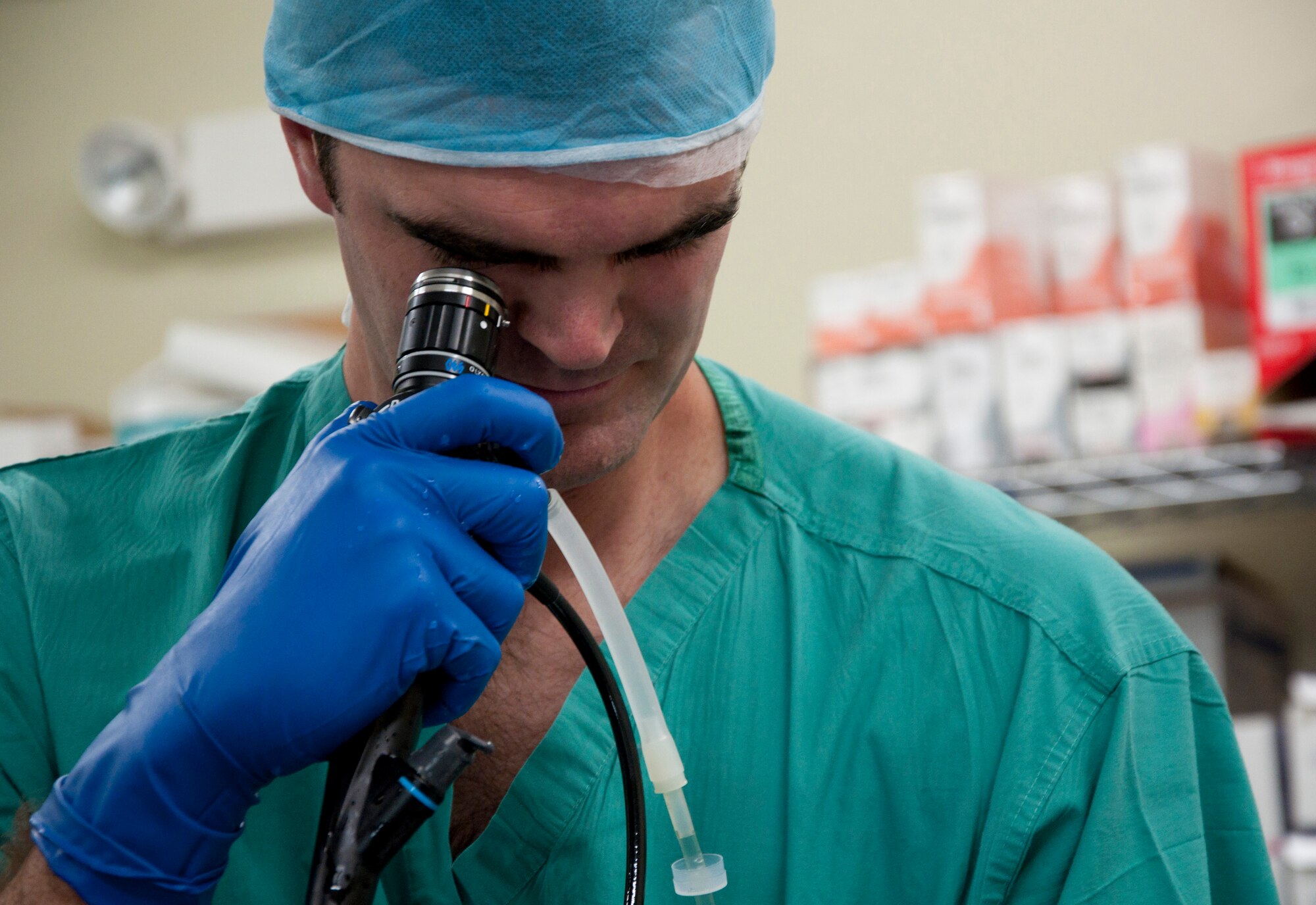 U.S. Air Force Maj. (Dr.) Toby Lees, urologist, peers through a scope during a urology procedure scheduled as part of a New Horizons Belize 2014 medical readiness training exercise May 22, 2014, at the Karl Heusner Memorial Hospital in Belize City, Belize. A U.S. Air Force surgical team arrived in Belize to spend two weeks conducting urology procedures and surgeries in coordination with the KHMH urologist. Approximately 40 patients were screened through the KHMH, and about 20 procedures are planned during this phase of the training exercise. (U.S. Air Force photo by Tech. Sgt. Kali L. Gradishar/Released)