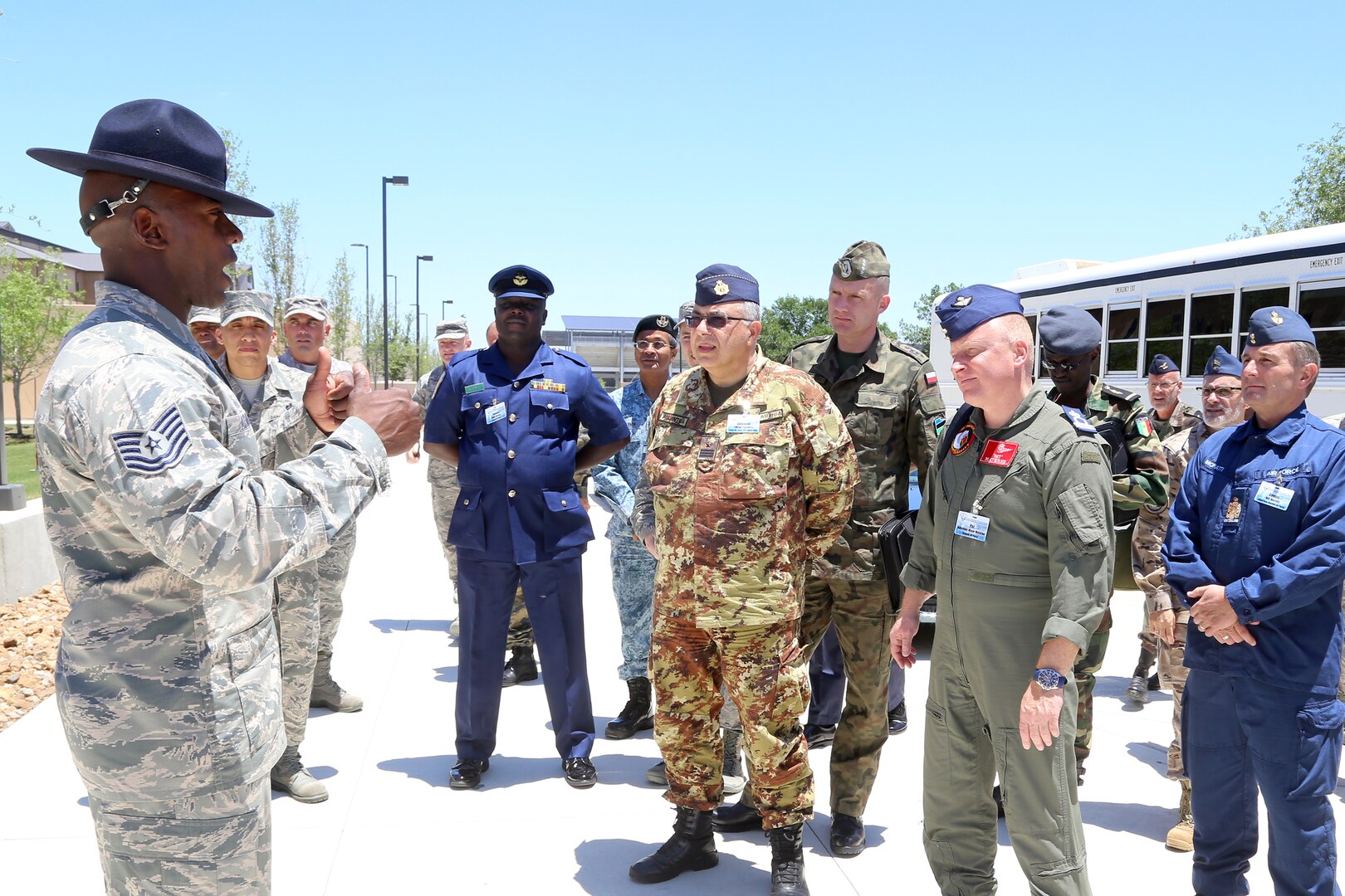 A Military Training Instructor speaks with senior enlisted leaders from the air forces of 24 countries as they tour basic military training facilities at Joint Base San Antonio-Lackland, Texas. Chief Master Sgt. of the Air Force James Cody hosted an international senior enlisted leader summit May 13-16. (U.S. Air Force photo by Joshua Rodriguez)