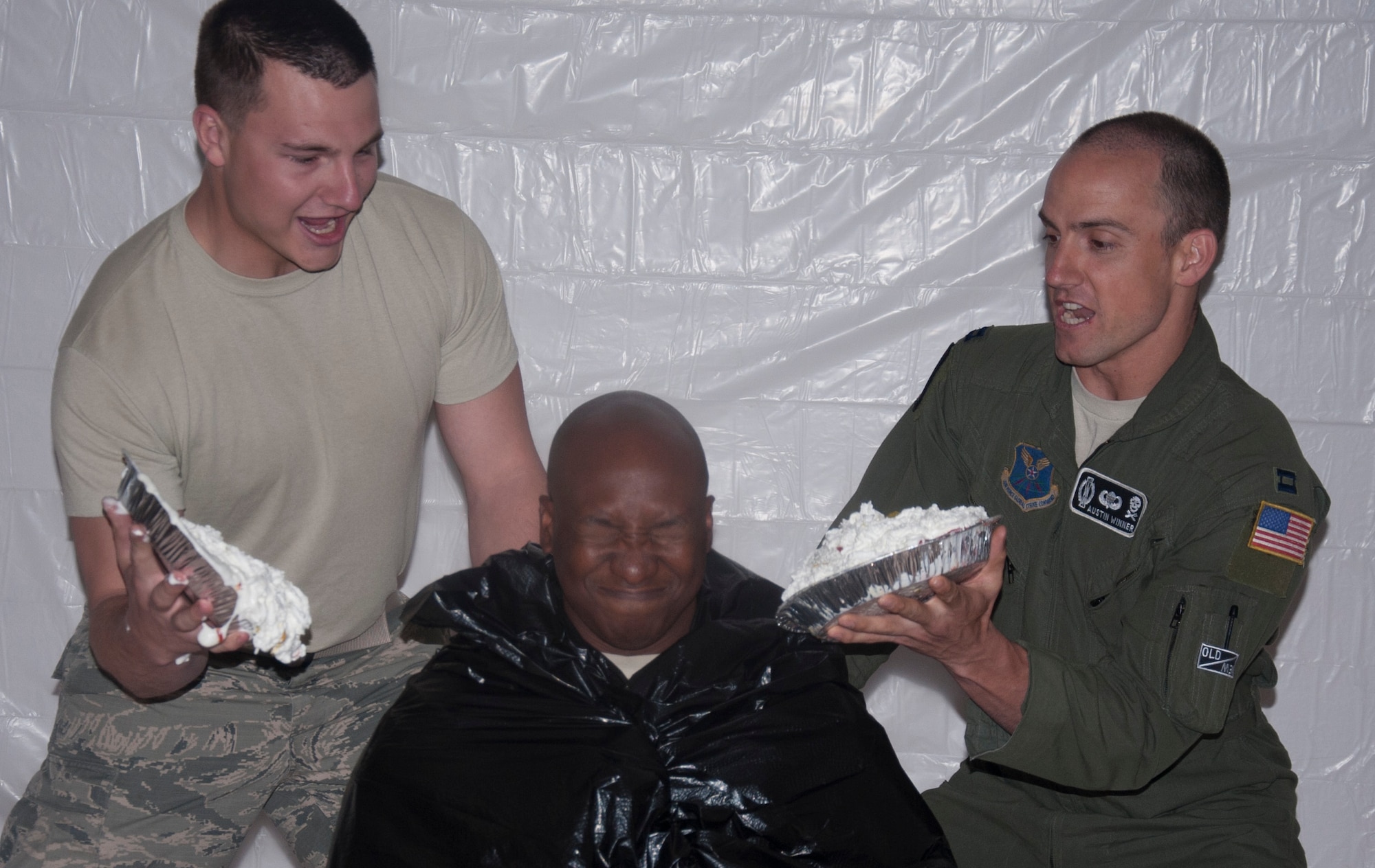 Capt. Austin Winner, 90th Operations Group, and Airman 1st Class Daniel Davitt, 90th Medical Operations Squadron, prepare to slam two whipped-cream pies into the face of Col. Carl Jones, 90th Missile Wing vice commander, during the wing’s burger burn fundraiser May 27 at the Fall Hall Community Center. After an intense bidding war to see who would be given the honor of pie-ing Jones, a second pie was awarded, thus raising twice the money.