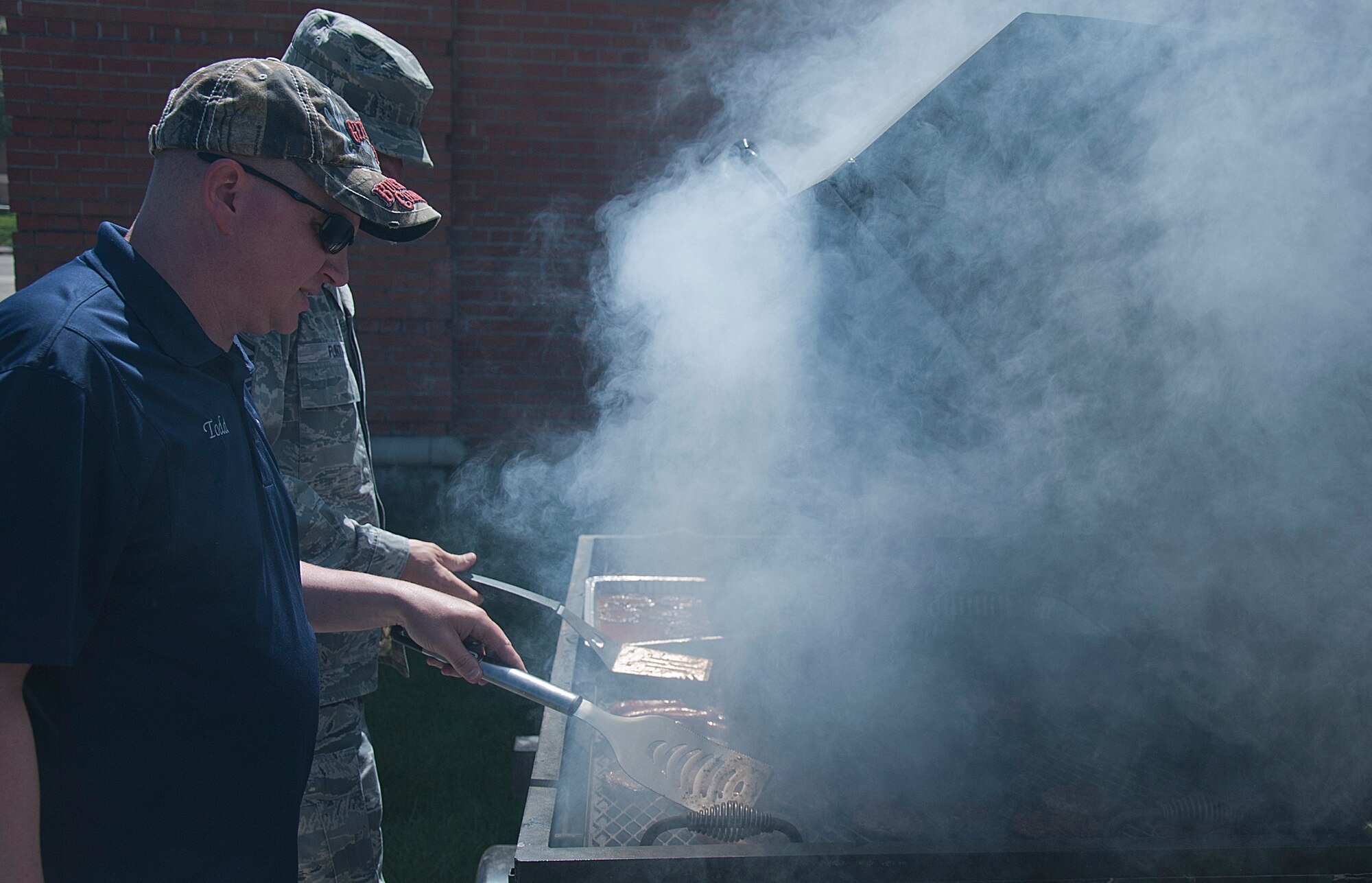 Jerry Todd, 90th Civil Engineer Squadron, and Master Sgt. Daniel Flint, 90th Missile Maintenance Squadron first sergeant, grill burgers for the 90th Missile Wing burger-burn fundraiser May 27 at the Fall Hall Community Center. All proceeds are to be used for the wing’s dining out June 13.
