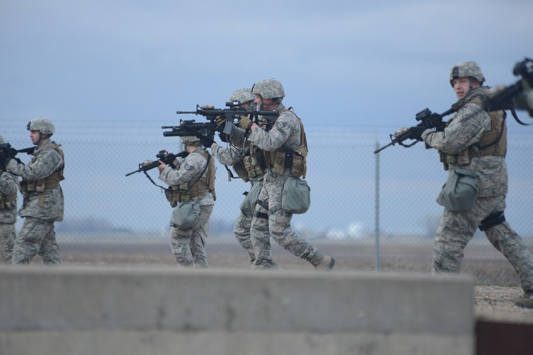 Staff Sgt. Shawn McElyea is at the center of a group of 219th Security Forces Squadron members simulating the recapture of a Minot Air Force Base, N.D., missile launch facility during a training exercise May 20, 2014. The North Dakota Air National Guard enlisted members are doing their annual training while performing the real-World mission of missile field security, which allows their active duty counterparts to catch up on other training and mission requirements.  (U.S. Air National Guard photo by SMSgt. David H. Lipp/Released)