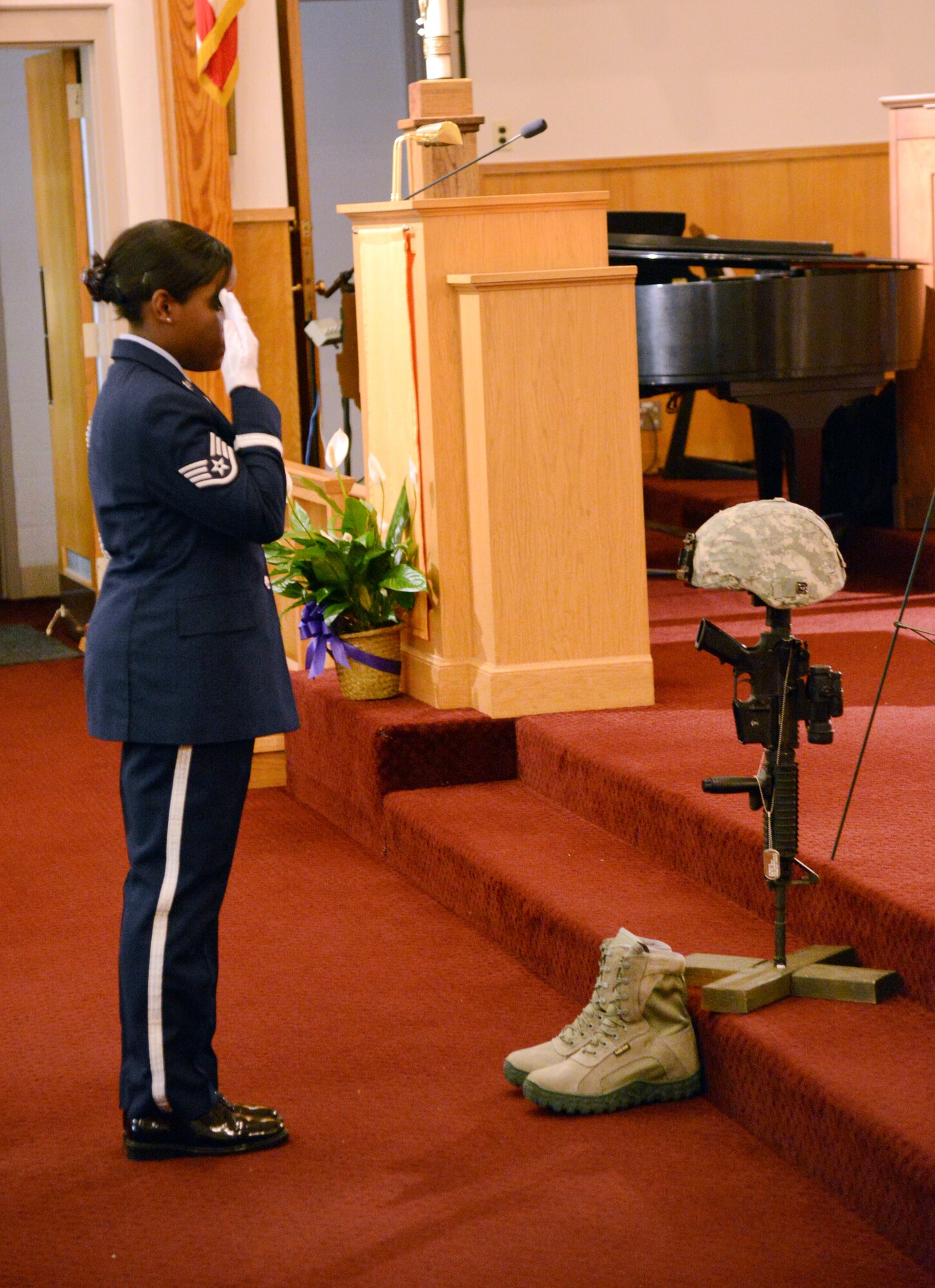 Staff Sgt. Evvanaire Brown, 72nd Security Forces Squadron, salutes the memorial of military and civilian police and first responders during the May 15 Remembrance Service to honor those who have fallen in 2013. During the ceremony  at the Tinker Chapel, Security Forces members read aloud 109 names of the fallen from each state and then saluted the memorial in honor of each one of them. The service was one of several National Police Week events. (Air Force photo by Kelly White)