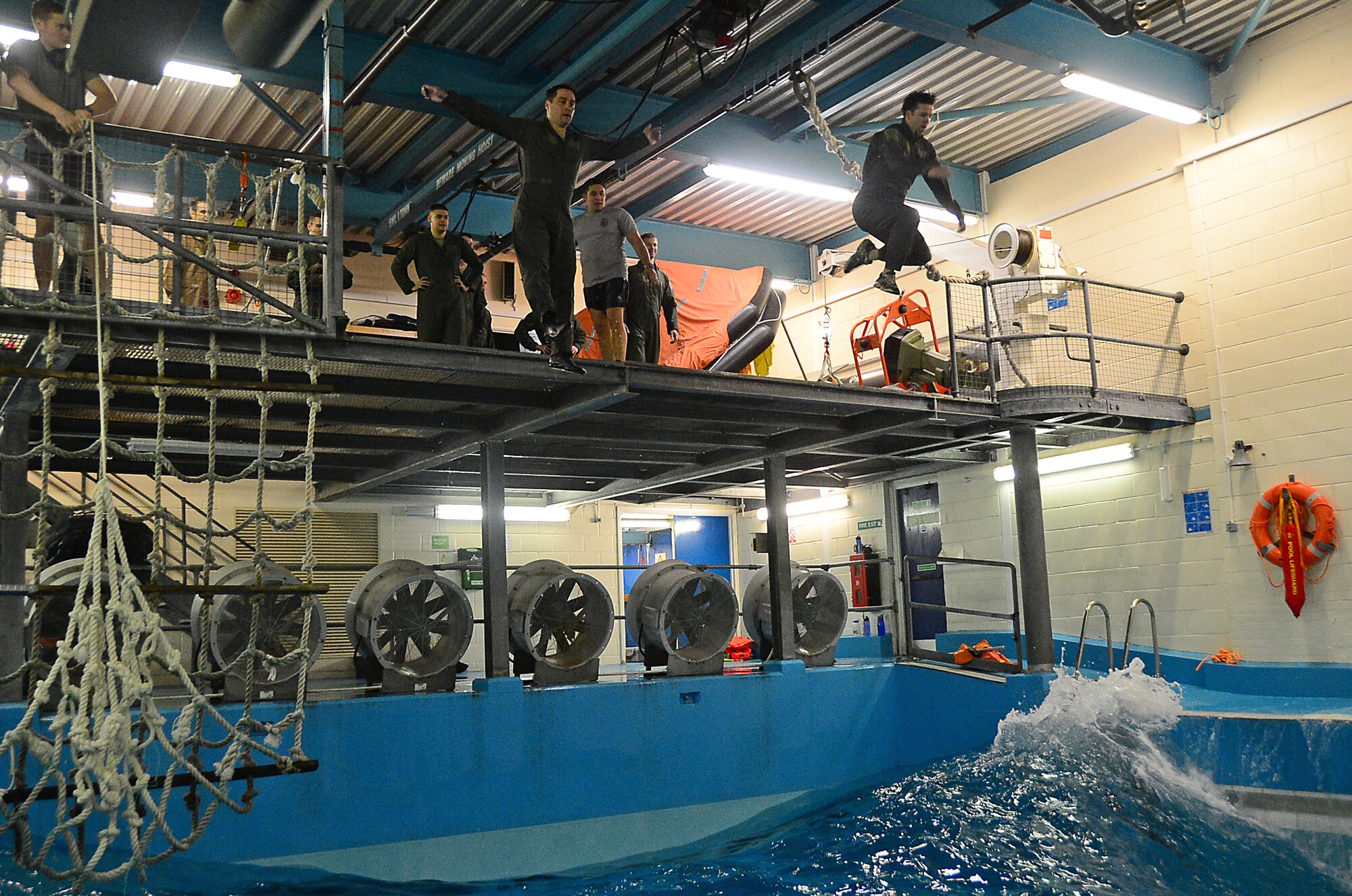 U.S. Air Force aircrew jump into 4-foot waves generated in a specialized facility at the Lowestoft College pool in Lowestoft, England, during a water survival training course led by U.S. Air Force survival training experts May 22, 2014. The class is mandatory for aircrew operating over a body of water. Harsh sea conditions off the coast of England present a major danger and can force pilots to adjust training flights to take place over land. Ultimately, this shift may lead to increased aircraft noise heard by U.K. communities. (U.S. Air Force photo by Airman 1st Class Erin O’Shea/Released)
