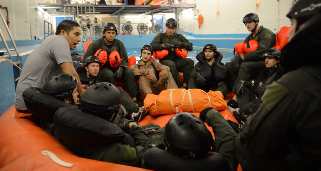 Fighter, air refueling and special operations aircrew participate in a water survival training course led by a U.S. Air Force survival training expert (grey) at the Lowestoft College pool in Lowestoft, England, May 22, 2014. The class is mandatory for aircrew operating over a body of water. Harsh sea conditions off the coast of England present a major danger and can force pilots to adjust training flights to take place over land. Ultimately, this shift may lead to increased aircraft noise heard by U.K. communities. (U.S. Air Force photo by Staff Sgt. Thomas Trower/Released)