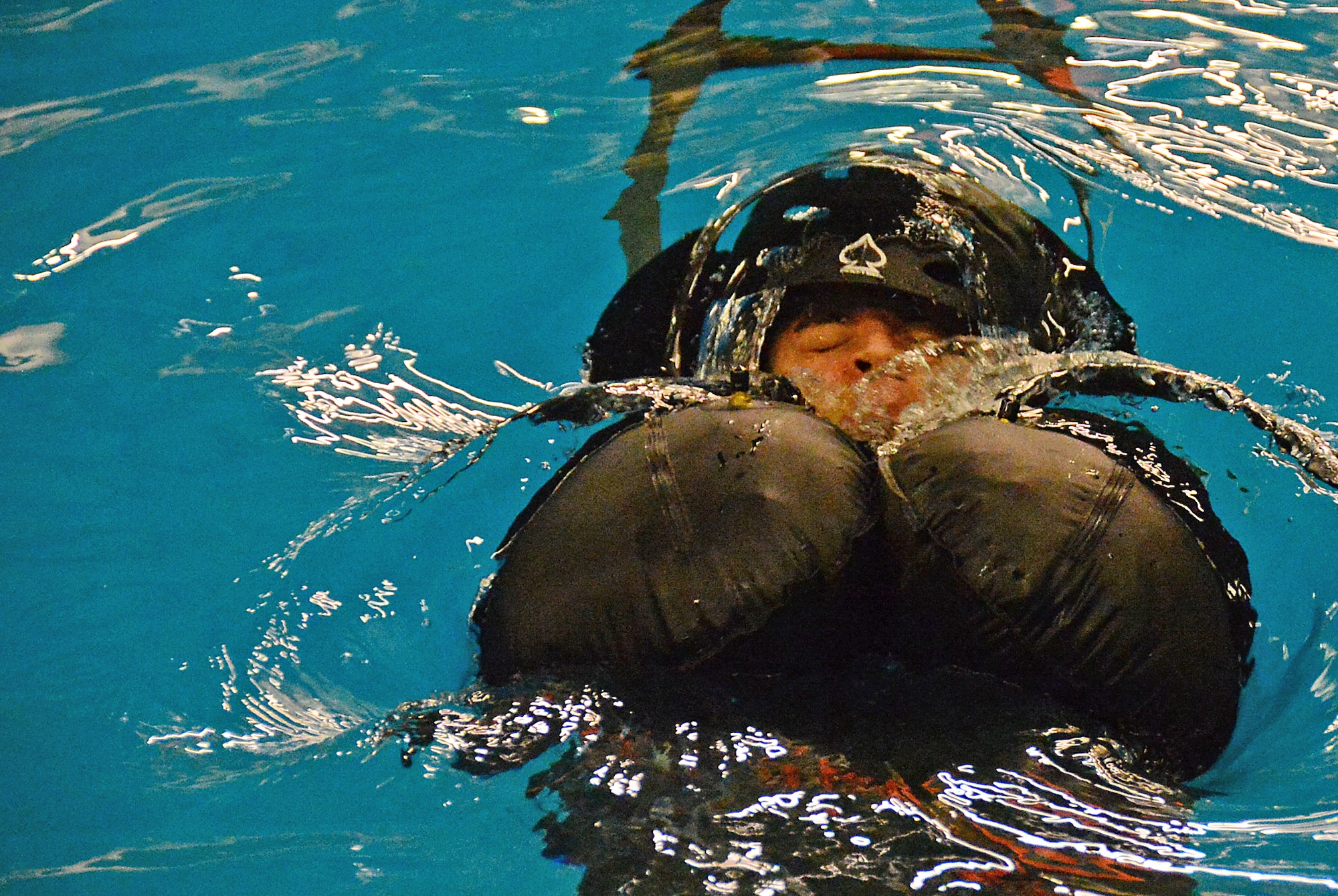 A student of the U.S. Air Force water survival training course submerges at the Lowestoft College pool in Lowestoft, England, during a course led by survival experts May 22, 2014. The class prepared aircrew for dangerous operating environments created by harsh weather conditions. When sea conditions are deemed too hazardous, flight training can be diverted over land, ultimately creating noise heard by local communities. (U.S. Air Force photo by Airman 1st Class Erin O’Shea/Released)