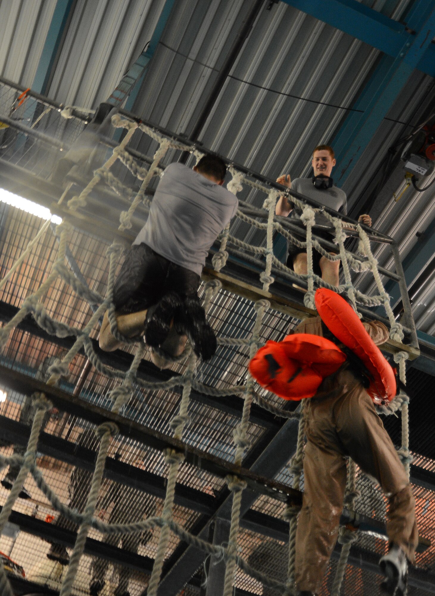 A U.S. Air Force Survival, Evasion, Resistance and Escape instructor (left) demonstrates the proper use of a recovery net commonly found on ships, to Airman 1st Class Trevor McBride, 48th Fighter Wing Public Affairs photojournalist, during a water survival training course at the Lowestoft College pool in Lowestoft, England, May 22, 2014. The class prepared aircrew for dangerous environments created by harsh weather conditions over water off the U.K. coastline. The 48th Fighter Wing’s strategic, European-based location enables the unit to support U.S. Air Forces in Europe’s “Forward, Ready, Now” posture by providing worldwide, responsive, combat airpower. (U.S. Air Force photo by Staff Sgt. Thomas Trower/Released)