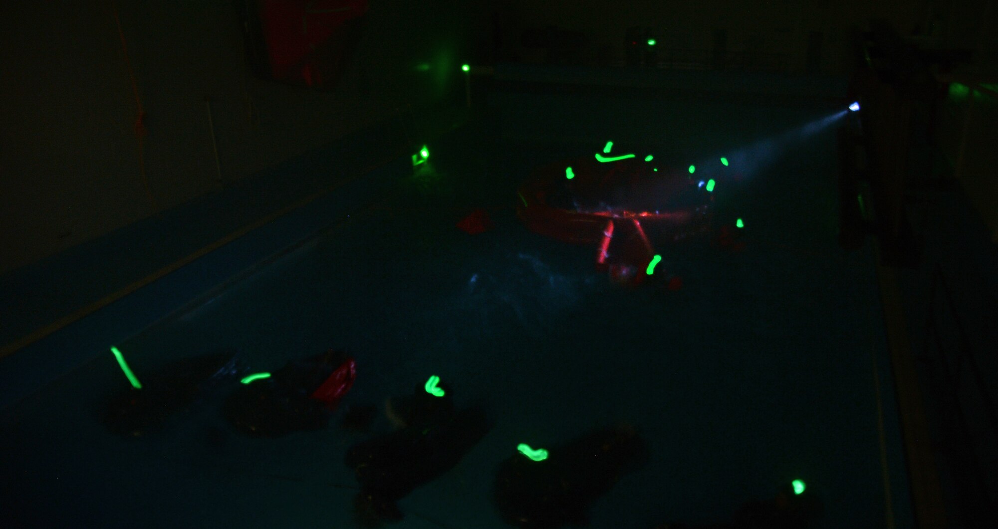 During an exercise in blackout conditions, fighter, air refueling and special operations aircrew participate in a water survival training course led by U.S. Air Force survival training experts at the Lowestoft College pool in Lowestoft, England, May 22, 2014. Students faced torrential rain, 4-foot waves, simulated lightning and gale-force winds during the class. Harsh sea conditions off the coast of England present a major danger and can force pilots to adjust their training flights to take place in airspace over land, ultimately leading to increased aircraft noise heard by U.K. communities. (U.S. Air Force photo by Staff Sgt. Thomas Trower/Released)
