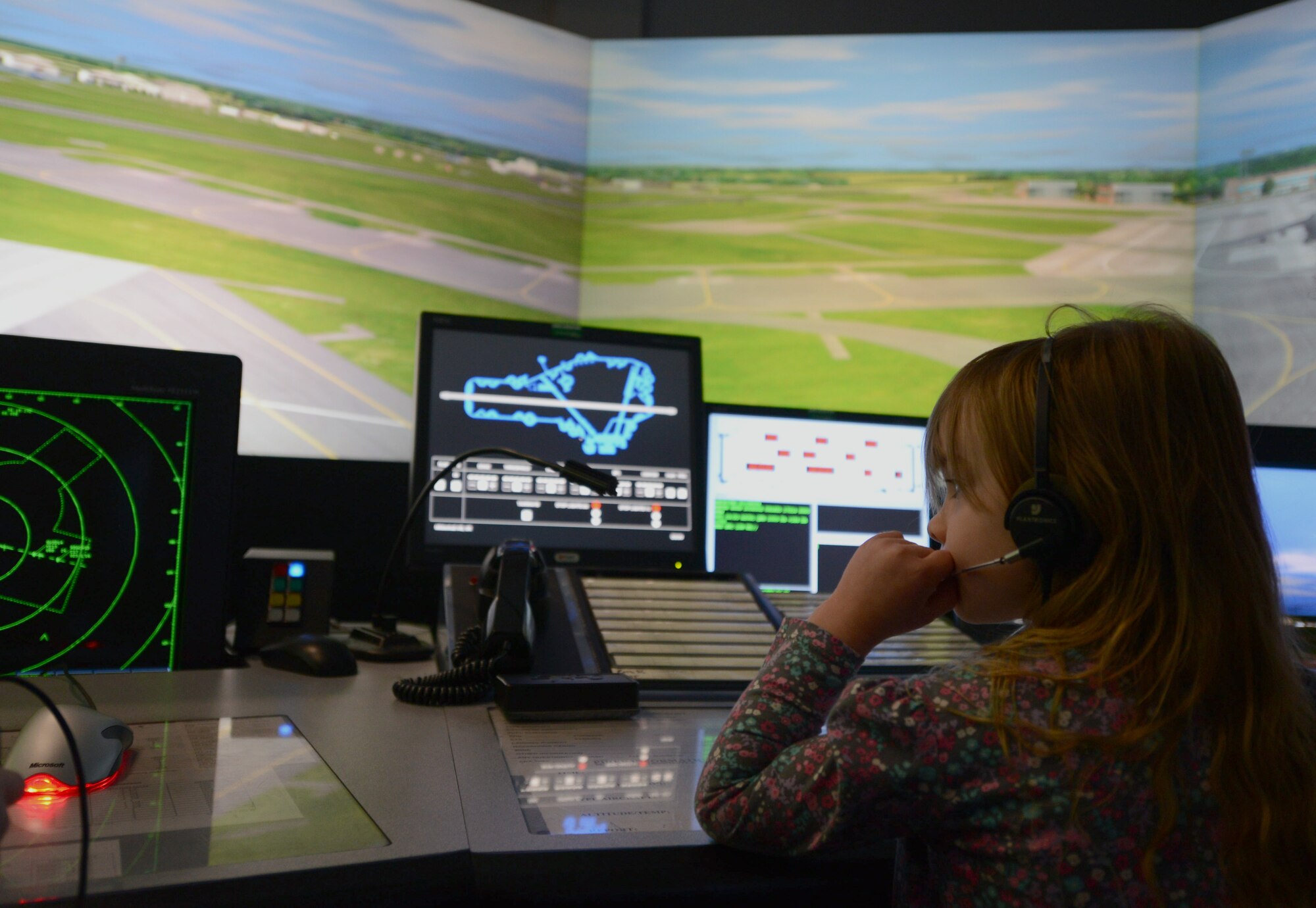 Analyse King, 5, daughter of Master Sgt. Virginia King, 352nd Special Operations Group man power and organization superintendent, uses an air traffic control simulator May 23, 2014, during the Team Mildenhall job shadow day on RAF Mildenhall, England. Many squadrons on base set up displays and events to give children the opportunity to see different job perspectives. (U.S. Air Force photo by Airman 1st Class Kyla Gifford/Released)