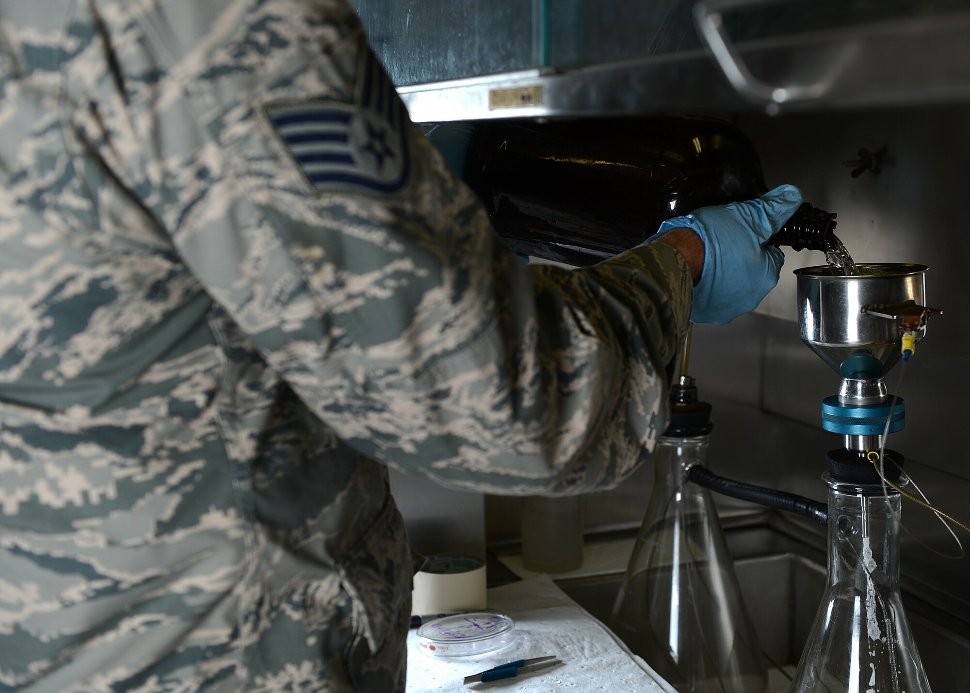 U.S. Air Force Staff Sgt. Mark Harschfeld, 52nd Logistics Readiness Squadron NCO in charge of the fuels laboratory and Helena, Mont., native, pours JP-8 fuel into a filtering flask at Spangdahlem Air Base, Germany, May 23, 2014. Laboratory technicians perform approximately 20 tests daily to ensure top quality of fuel. (U.S. Air Force photo by Airman 1st Class Kyle Gese/Released)