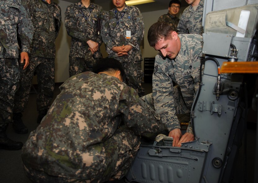 Staff Sgt. Jory Reynolds, 8th Maintenance Squadron aircrew egress systems craftsman, shows Republic of Korea maintainer how to fit the specialized Red Flag Alaska seat kit at Kunsan Air Base, Republic of Korea, May 21, 2014. The 8th OSS AFE office hosted several Republic of Korea AFE and maintenance Airmen to share knowledge on how and what to pack ROKAF’s first F-16 Fighting Falcon flight to exercise Red Flag Alaska. (U.S. Air Force photo by Senior Airman Armando A. Schwier-Morales/Released)