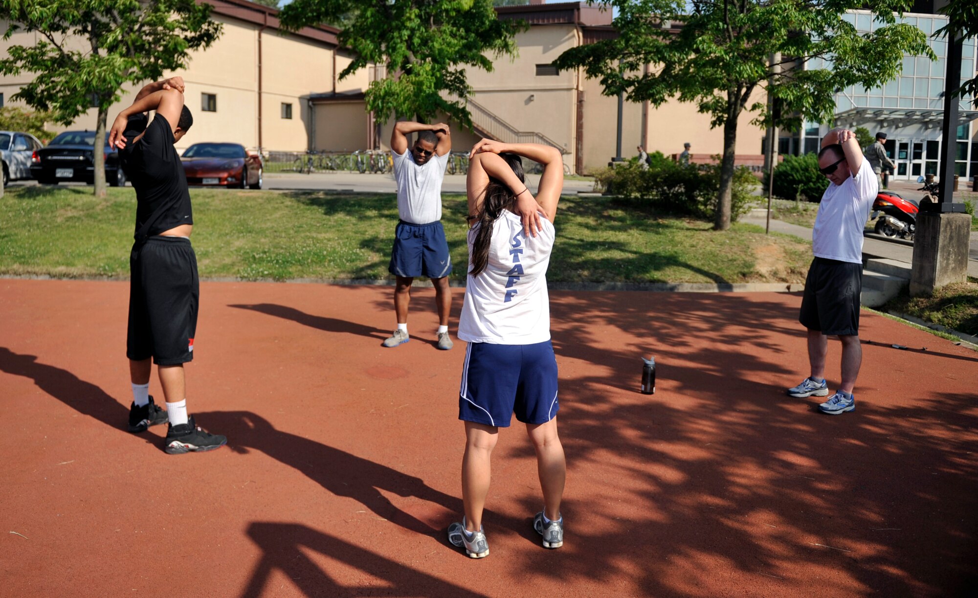 Staff Sgt. Josie Judice, 51st Force Support Squadron, leads Airmen in a cool down stretch after the workout during the Evolution 2 Excellence program May 21 on Osan Air Base, Republic of Korea. The Airmen ran 2.8 miles and performed calisthenics during the workout. (U.S. Air Force photo by Senior Airman David Owsianka)
