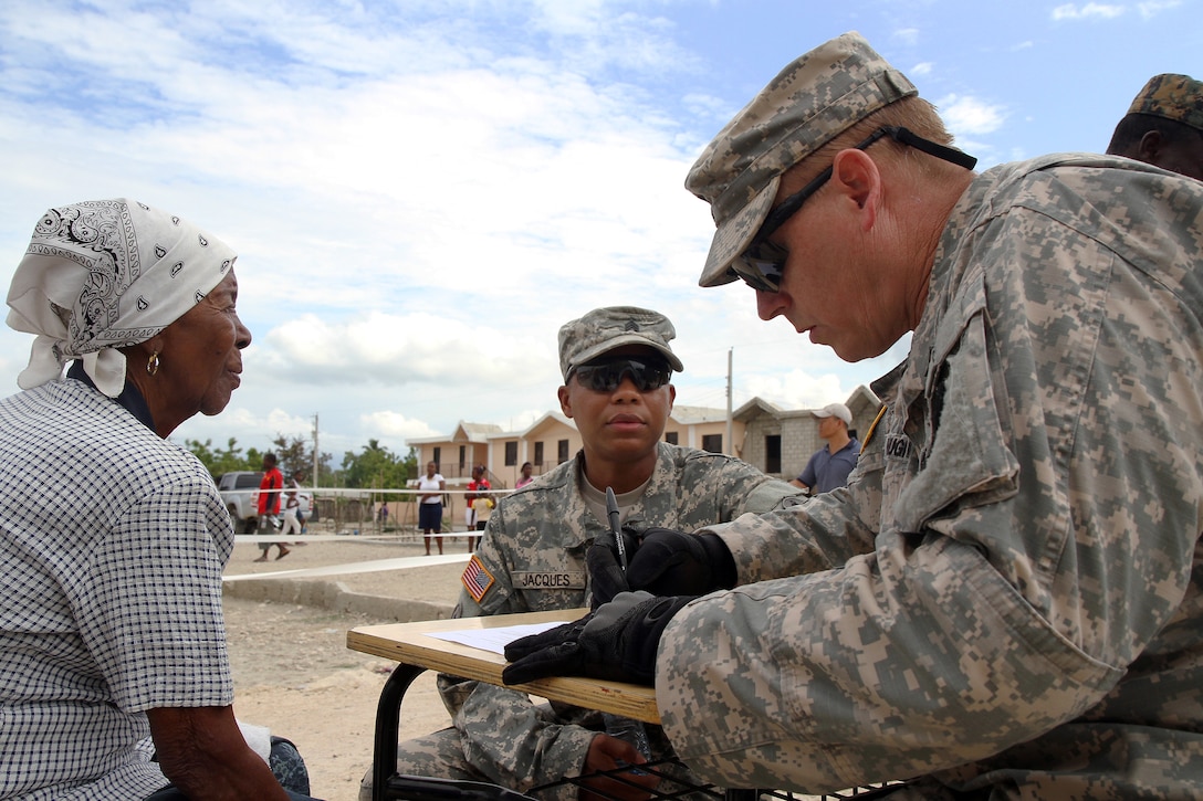 U.S. Army Master Sgt. Robert Hughes, right, writes down a patient's information as U.S. Army Sgt. Leonardo H. Jacques translates for him during Beyond the Horizon 2014 in Barahona, Dominican Republic, May 19, 2014. The mission provides humanitarian assistance to Latin American countries. Hughes and Jacques are assigned to Task Force Larimar.