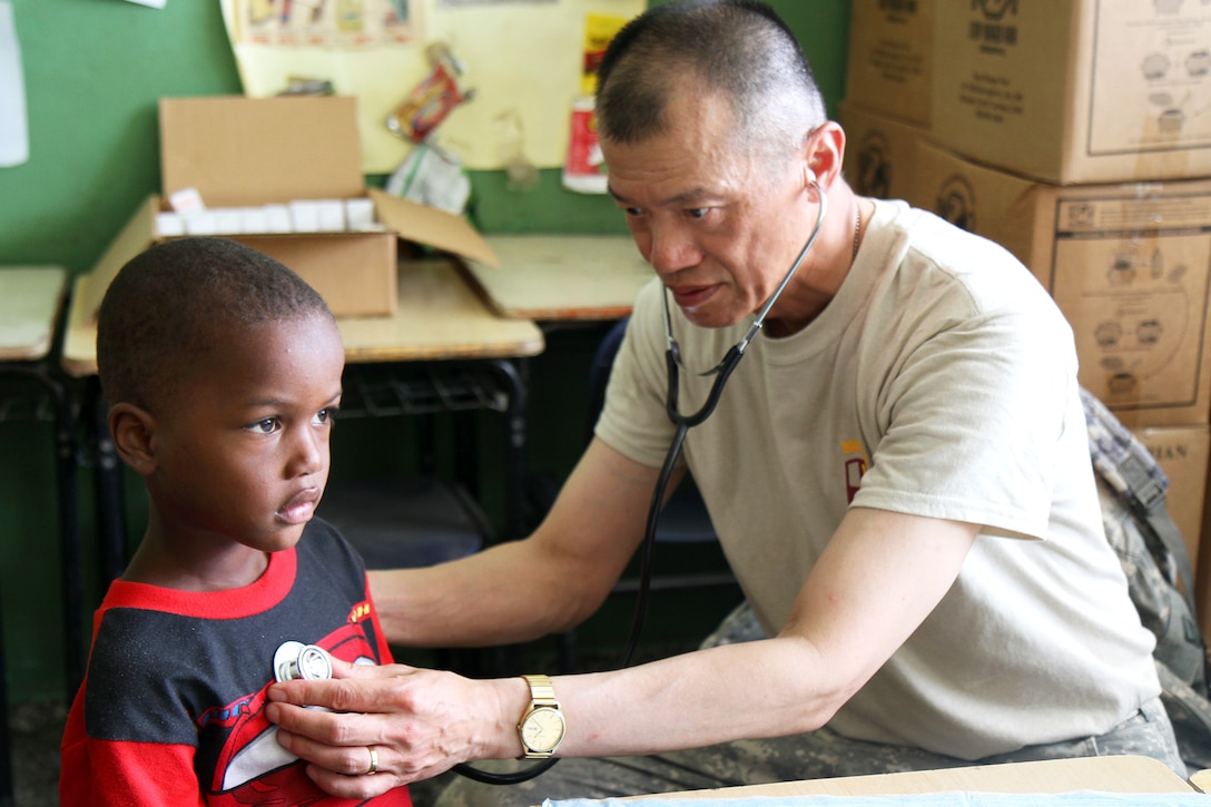 U.S. Army Lt. Col. Jack C. Leong, right, examines a child's chest during Beyond the Horizon 2014 in Barahona, Dominican Republic, May 19, 2014. Leong is a doctor assigned to the 801st Combat Support Hospital.