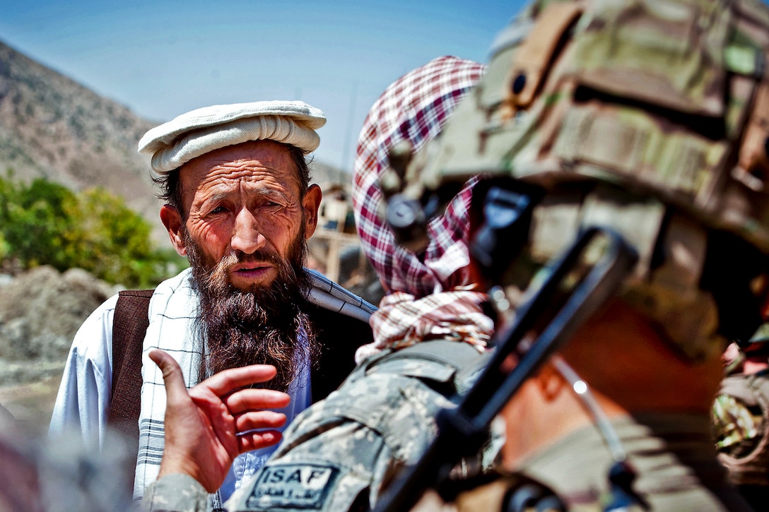 U.S. Air Force Lt. Col. Eric Shafa, foreground, speaks with an Afghan man through an interpreter about a recent road repair project in Afghanistan's Kapisa province, Aug. 2, 2012. Shafa commands Provincial Reconstruction Team Kapisa, a unit that coordinates development projects across the province.  
