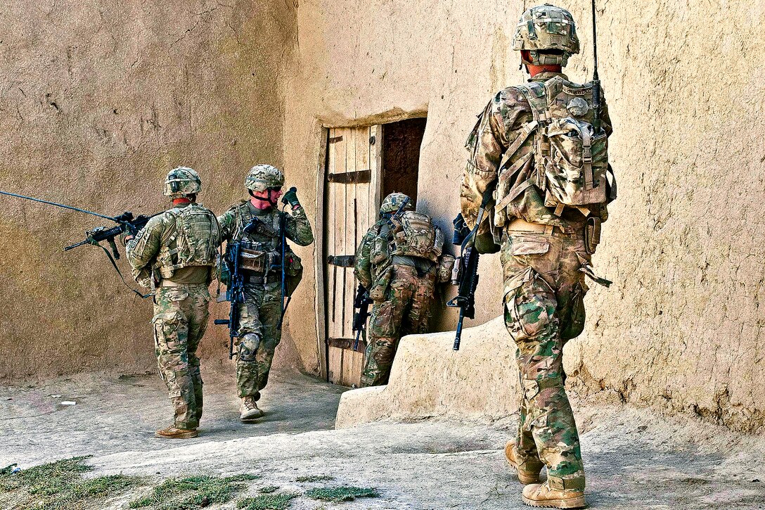 U.S. Army Sgt. 1st. Class Alan Sutton, 2nd from left, radios in an update as fellow paratroopers clear a compound during a foot patrol in Afghanistan's Ghazni province, Aug. 1, 2012. Sutton, a platoon leader, is assigned to the 82nd Airborne Division's Company A, 1st Battalion, 504th Parachute Infantry Regiment, 1st Brigade Combat Team.  
