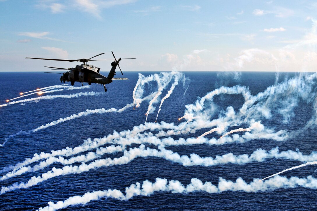 MH-60S Seahawk helicopters assigned to Helicopter Sea Combat Squadron 12 fire flares during a demonstration above the aircraft carrier USS Abraham Lincoln under way in the Atlantic Ocean, Aug. 6, 2012. The Lincoln is returning to the United States after completing an eight-month deployment during which it operated in areas of responsibility for the U.S. 5th, 6th and 7th fleets.  
