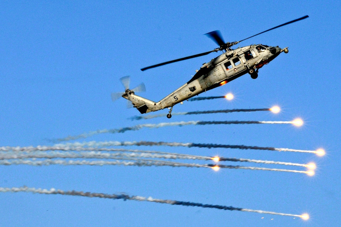 An MH-60S Seahawk helicopter launches flares during practice for an upcoming demonstration in the skies above the aircraft carrier USS Abraham Lincoln under way in the Mediterranean Sea, July 25, 2012. The helicopter crew is assigned to Helicopter Sea Combat Squadron 12. The Lincoln is on a scheduled deployment to support maritime security operations and theater security cooperation efforts in the U.S. 6th Fleet area of responsibility.  
