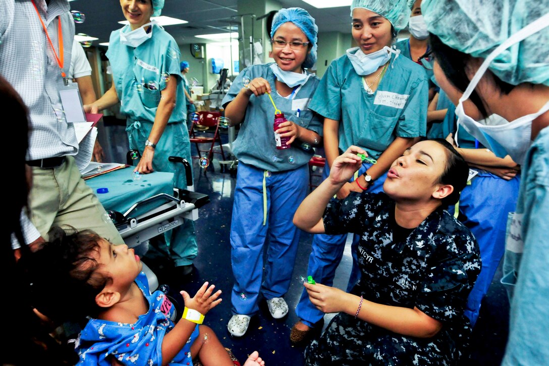 U.S. Navy Petty Officer 3rd Class Priscilla Saintcyr blows bubbles for a Cambodian boy before surgery aboard the Military Sealift Command hospital ship USNS Mercy during Pacific Partnership 2012 in Sihanoukville, Cambodia, Aug. 1, 2012. Cambodia is the final port for Pacific Partnership 2012, an annual U.S. Pacific Fleet humanitarian and civic assistance mission. Previous stops included Indonesia, the Philippines and Vietnam.  

