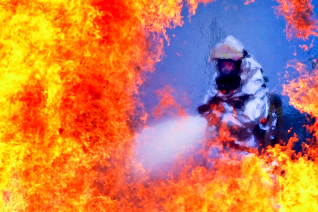 A firefighter extinguishes a blaze from a simulated plane crash during Beverly Midnight 12-03, an operational readiness exercise, on Osan Air Base, South Korea, July 23, 2012. The firefighter is assigned to the 51st Civil Engineer Squadron. Throughout the week, Osan airmen operated in a chemical environment and administered self-aid and buddy-care during a wartime environment.  
