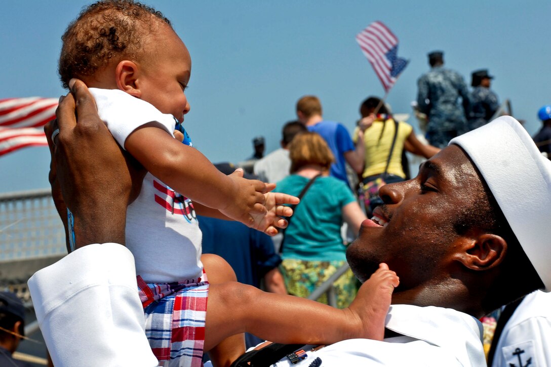 Navy Petty Officer 2nd Class Lawrence Brown holds his 9-month-old son after returning home from a six-month deployment aboard the guided-missile frigate USS Nicholas in Norfolk, Va., July 19, 2012. Nicholas was deployed to the Caribbean Sea and the eastern Pacific Ocean to support Operation Martillo, a narcotics interdiction mission. 
