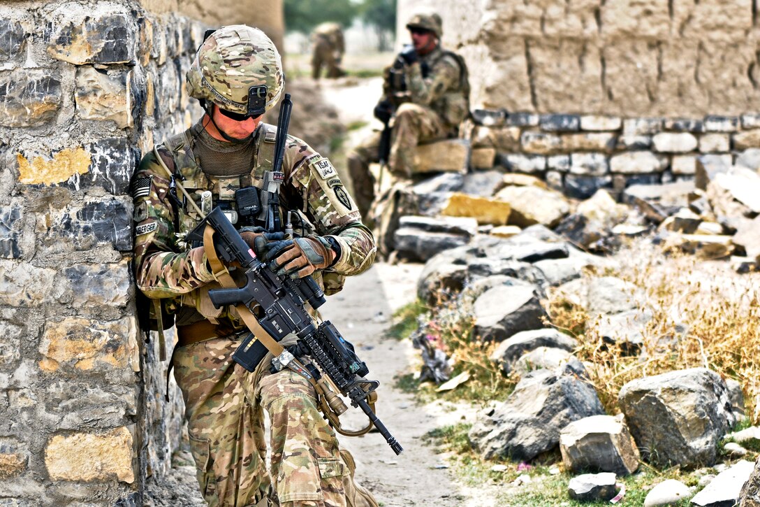 U.S. Army Sgt. Eric Rothenberger checks his sights while pulling security in an alleyway in the village of Kunday, Khost province, Afghanistan, July 7, 2012. Rothenberger is a team leader assigned to 2nd Battalion (Airborne), 377th Parachute Field Artillery Regiment. His unit's mission was to facilitate members of the female engagement team as they conducted key leader engagements to promote a female health education program.  
